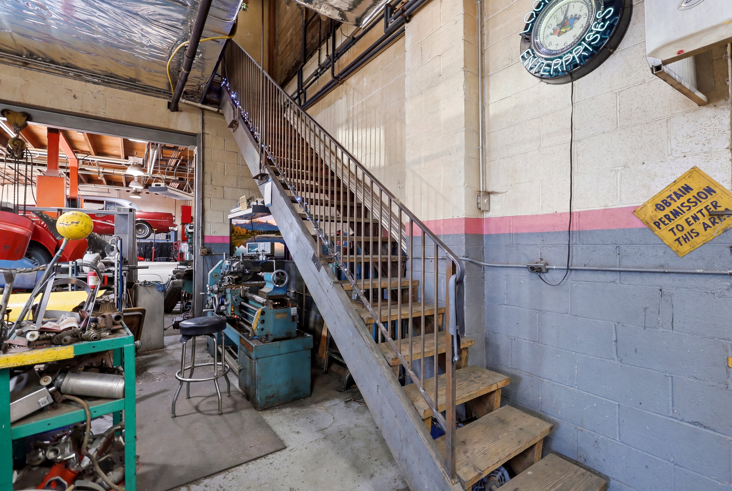 Industrial space featuring block walls, a durable concrete floor, and an open metal staircase with wood treads