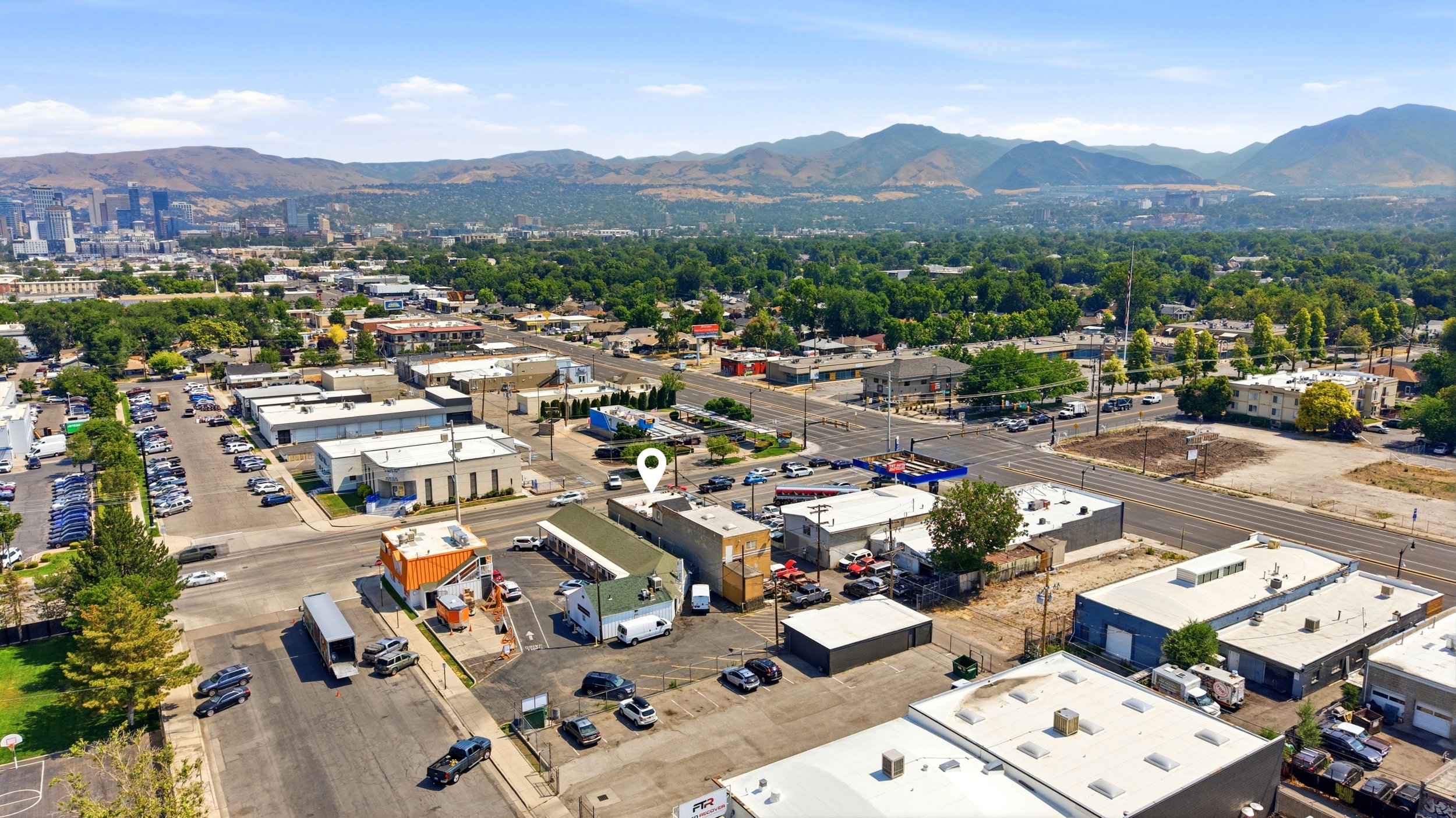 Aerial perspective showcasing commercial properties with surrounding mountains and urban skyline