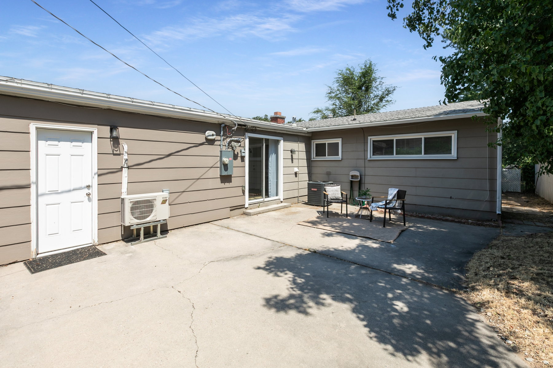 Concrete patio with a sliding glass door and multiple windows