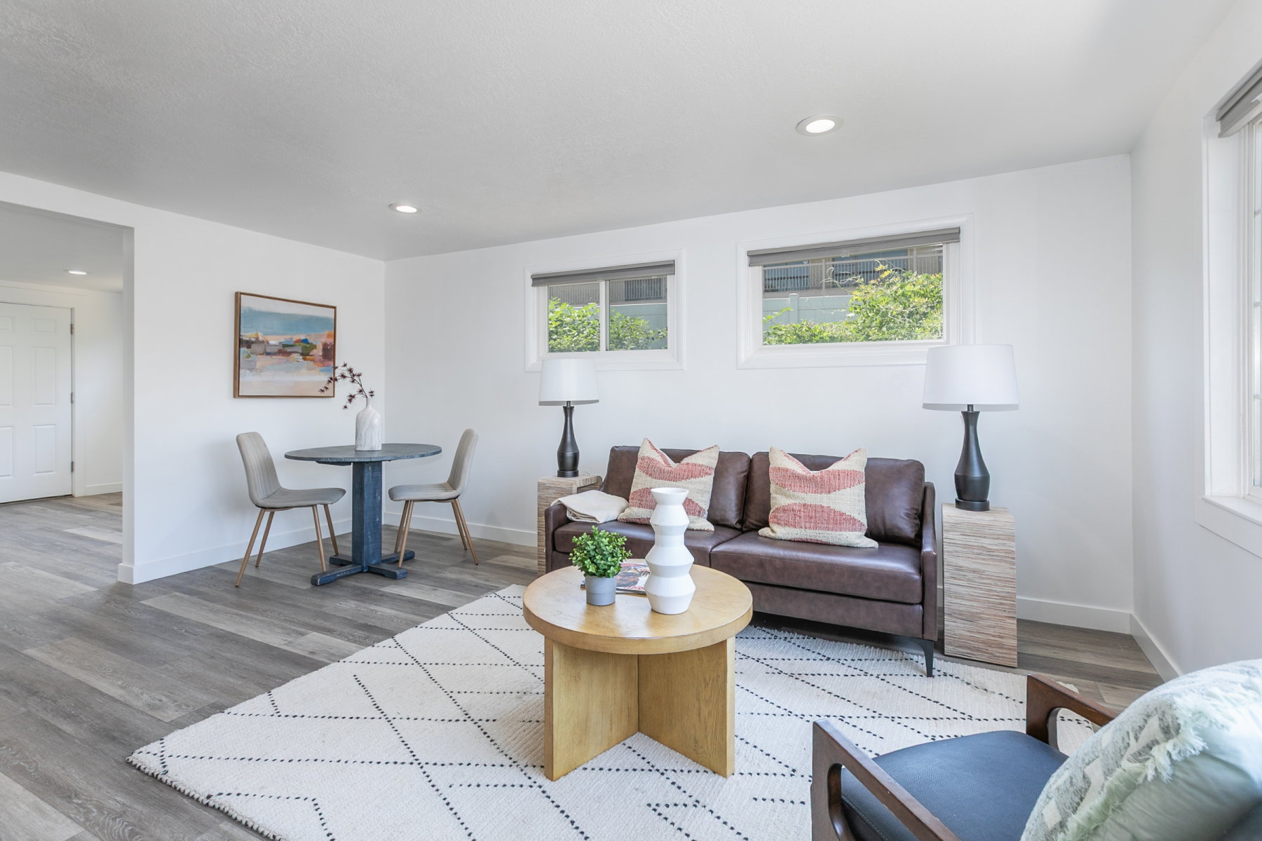 Living area featuring wood-finish flooring, recessed lighting, and white walls