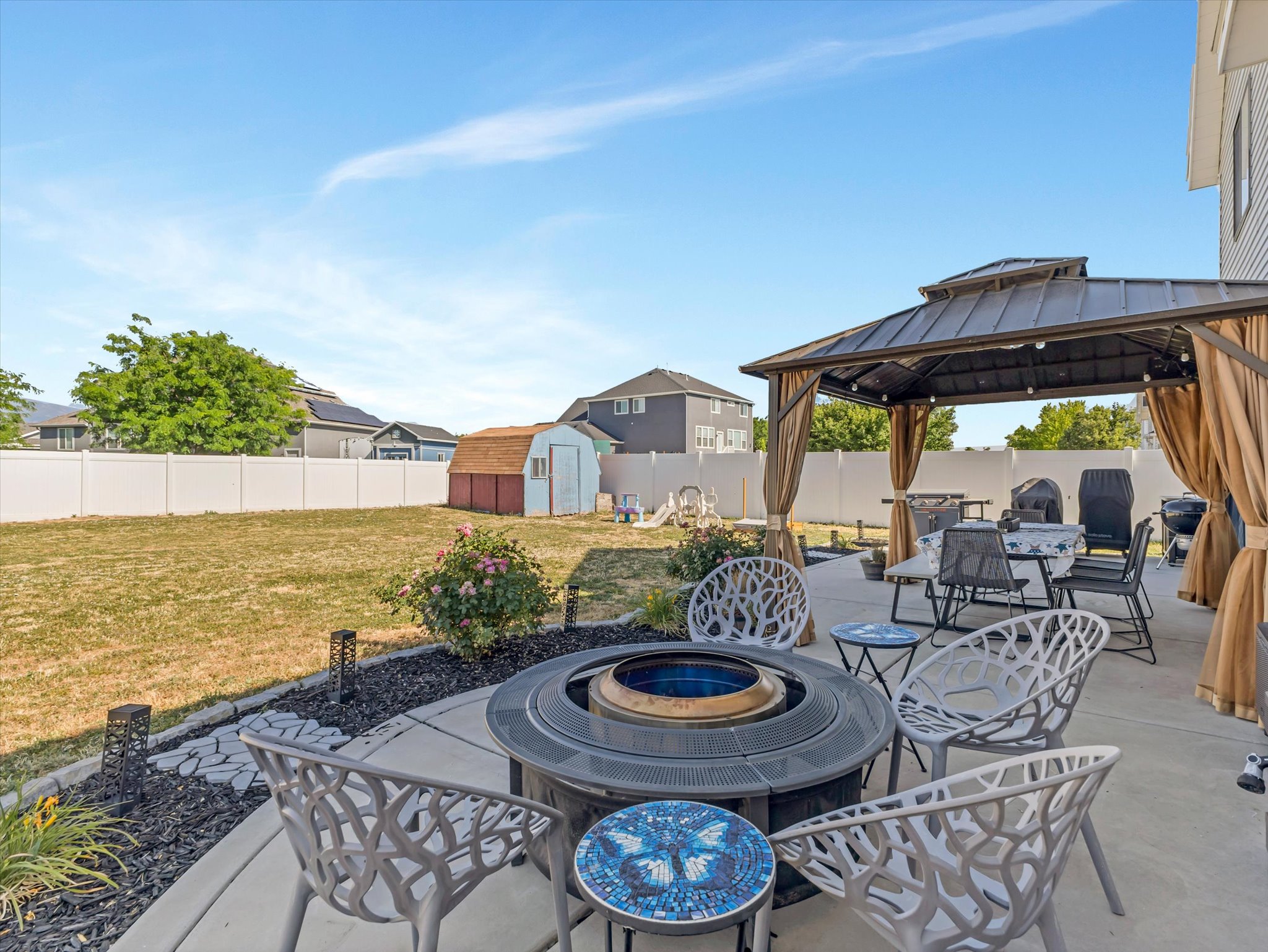 Concrete patio featuring a gazebo, fire pit, and a separate storage shed