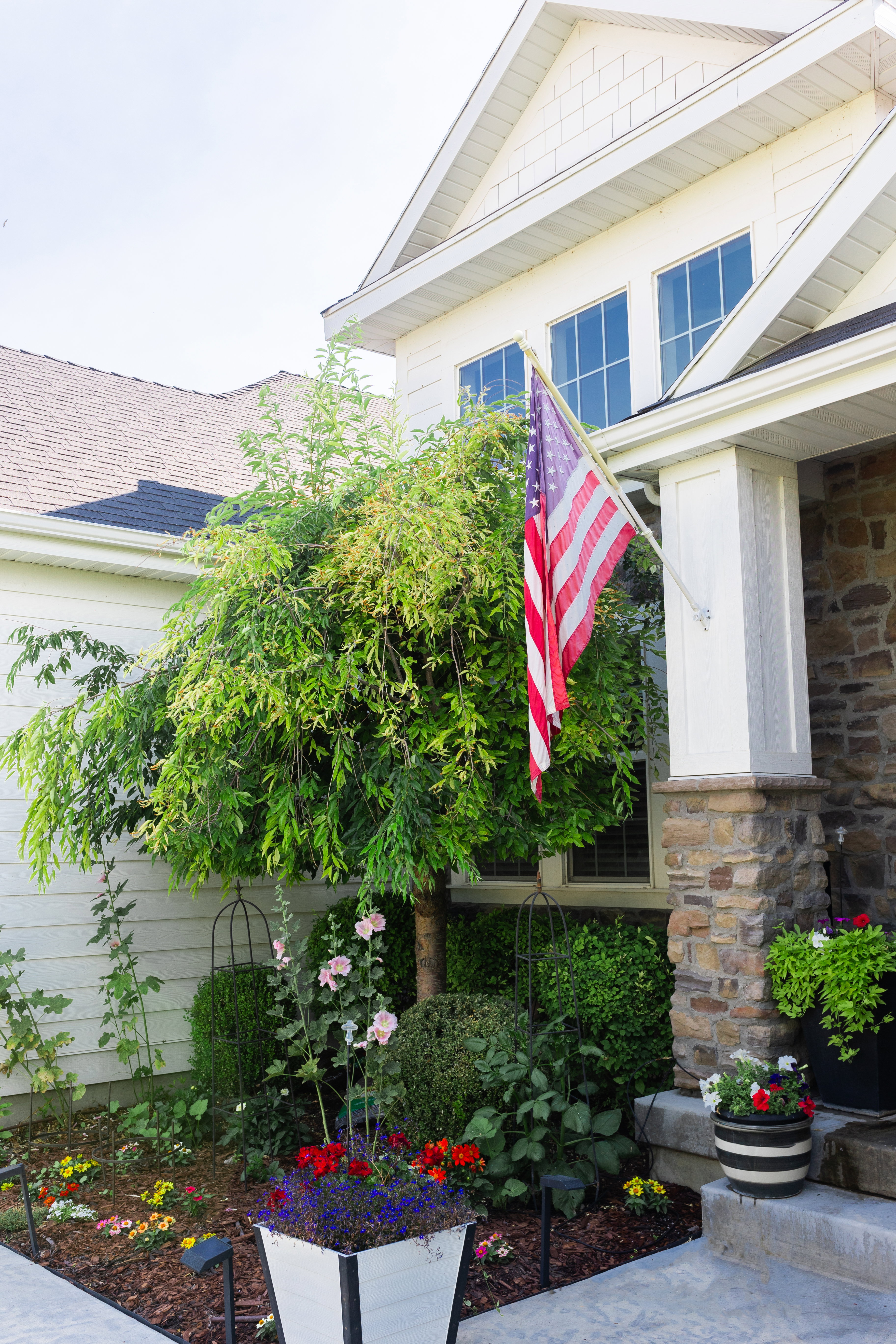 Stone veneer accents, white siding, and a gabled roofline define the exterior