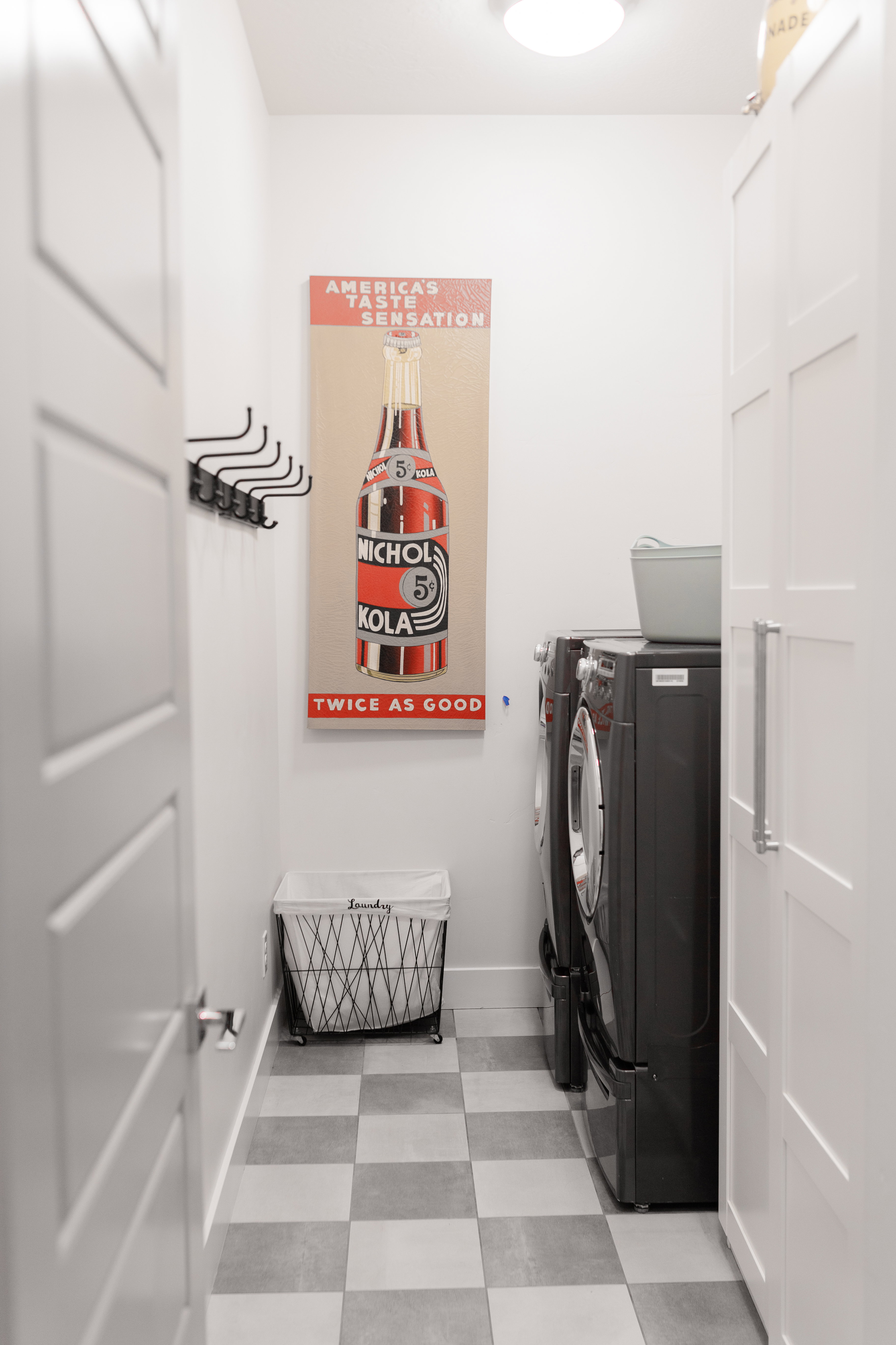 Dedicated laundry area featuring checkerboard-patterned flooring and integrated cabinetry with brushed metal hardware