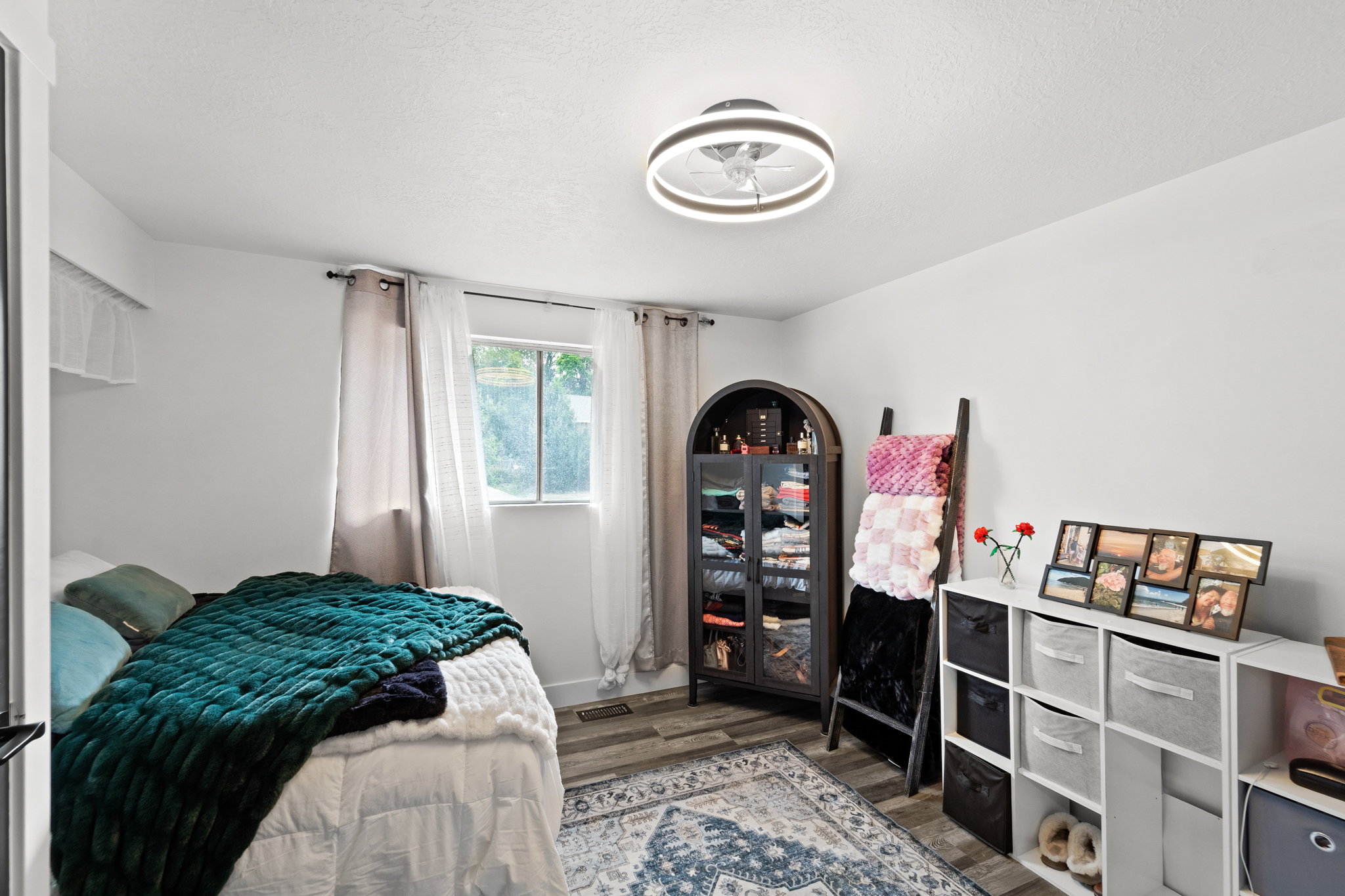 Bright room featuring a window with natural light, wood-finish flooring, and a contemporary ceiling fixture