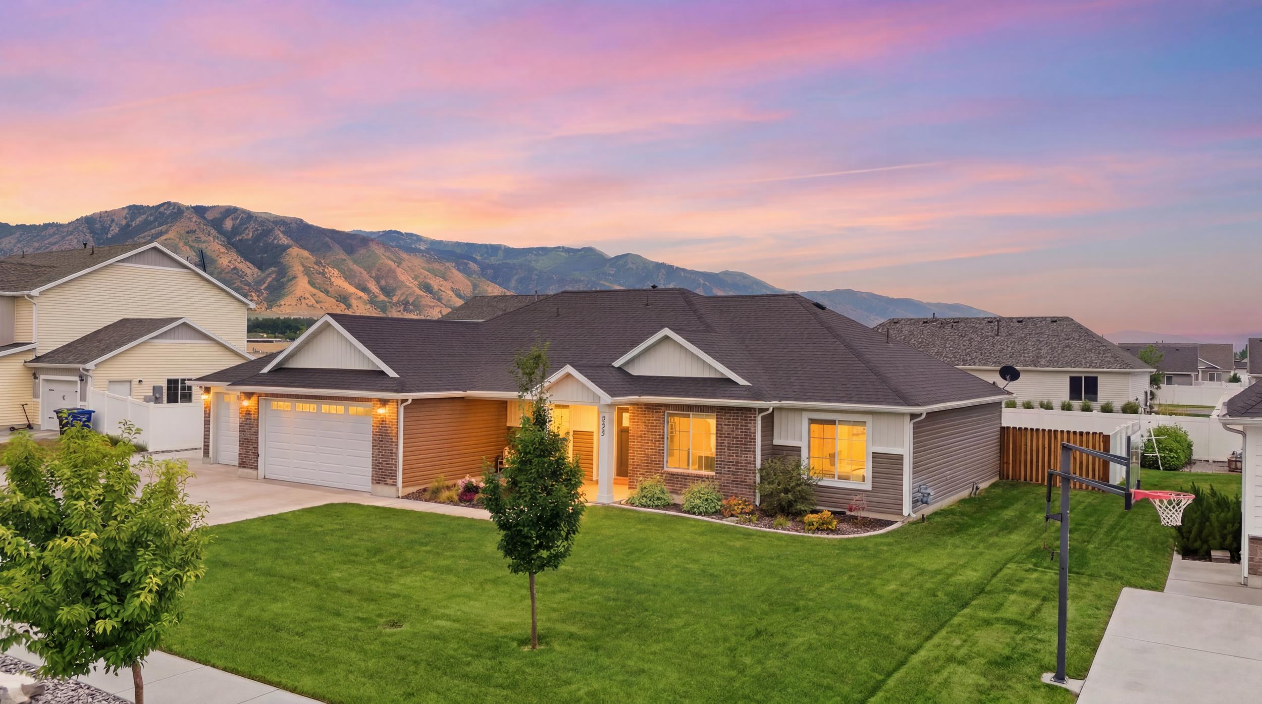 Contemporary single-story residence featuring a two-car garage, brick and siding exterior, and a dark shingle roof