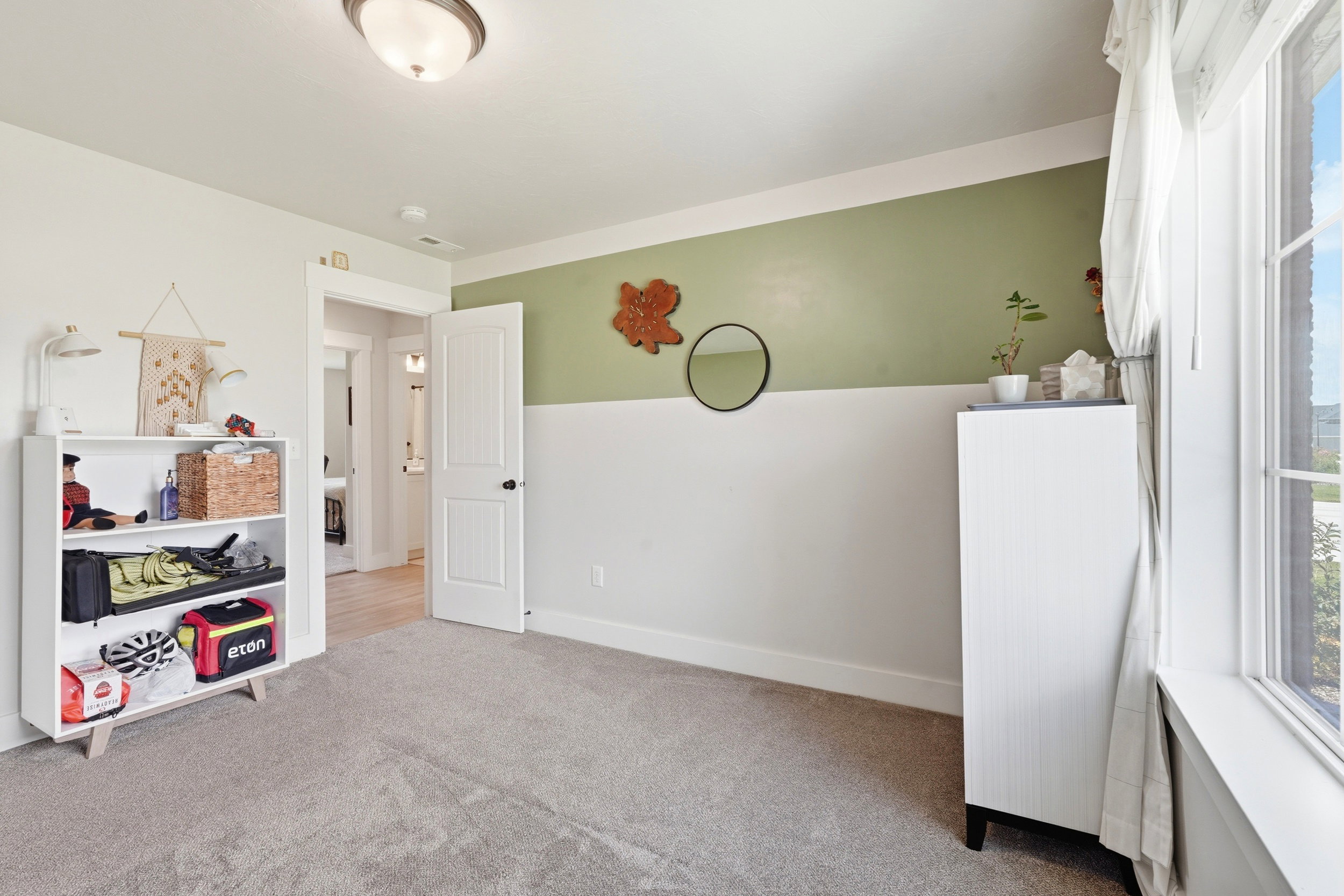 Carpeted room with a two-tone wall treatment, featuring a large window with white trim