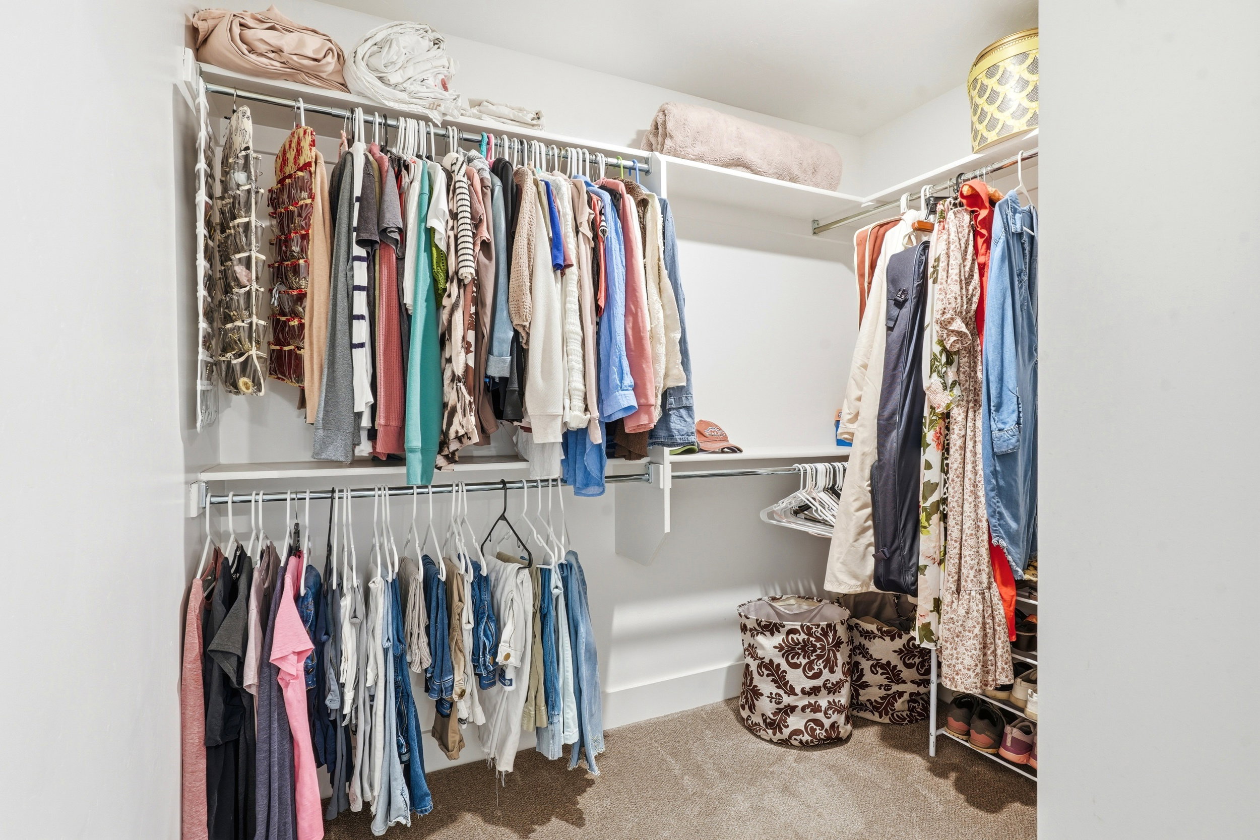 Walk-in closet featuring white walls, carpet flooring, and a multi-level wire shelving system