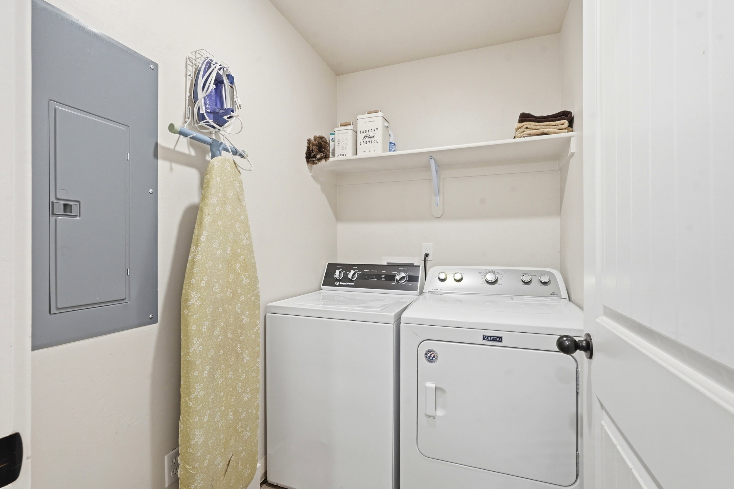 Dedicated laundry area with white walls and built-in shelving