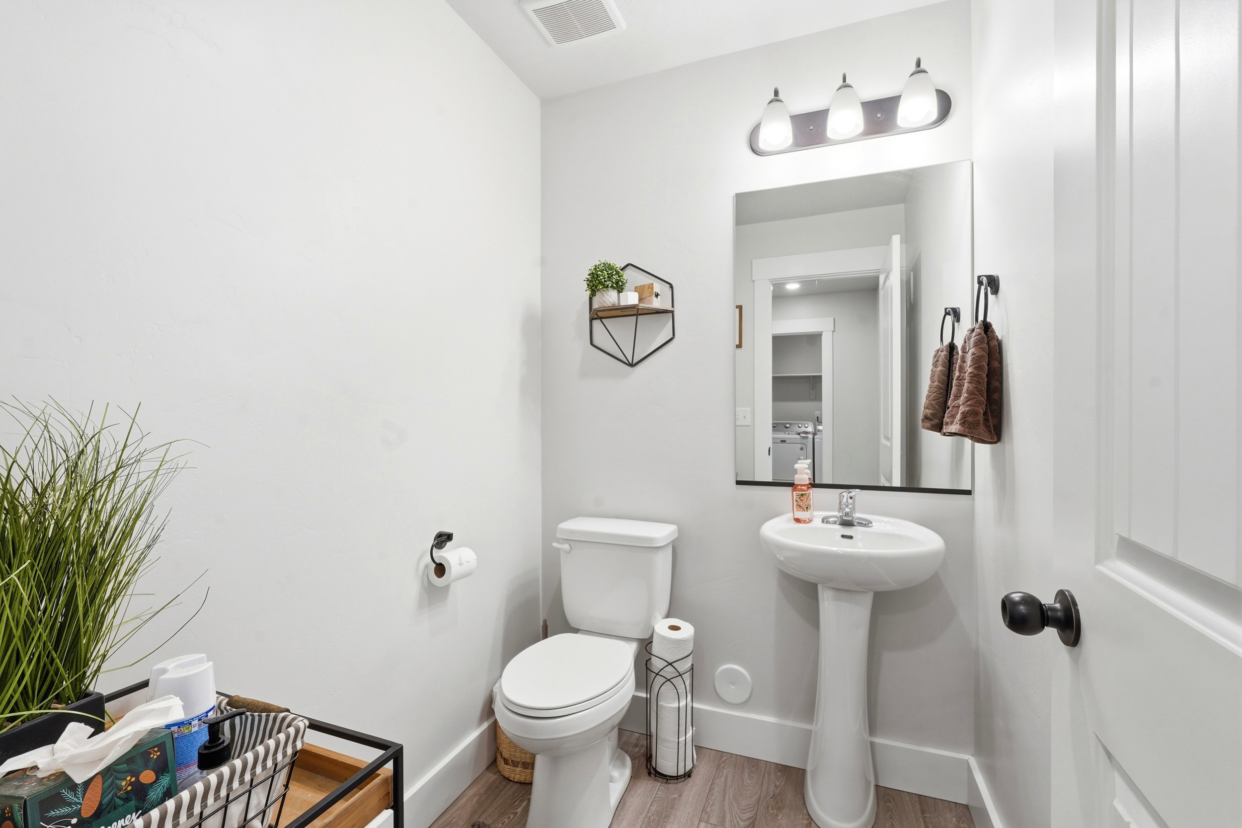 Pedestal sink with chrome faucet, flanked by a white toilet