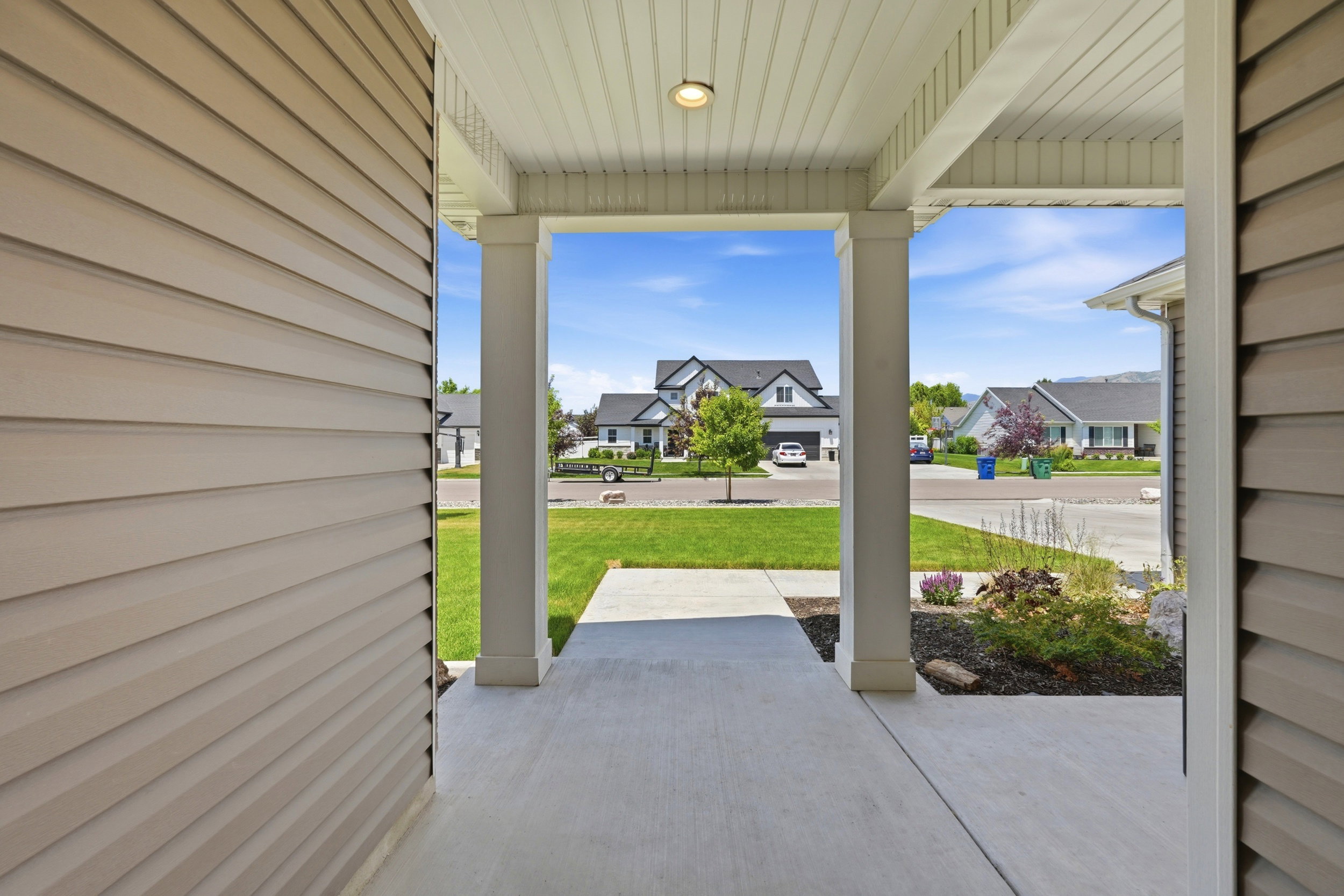 Inviting covered porch with a concrete walkway and beadboard ceiling