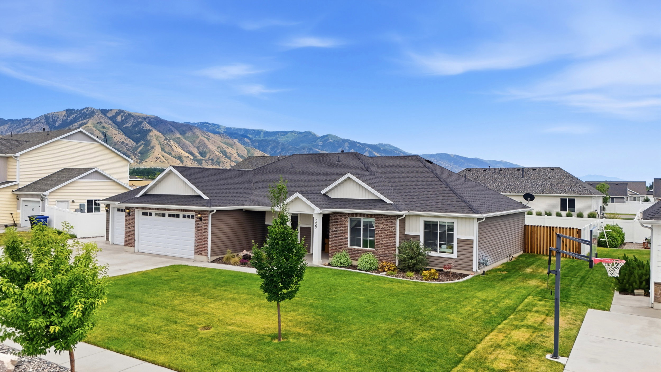 Single-story residence featuring a two-car garage, brick and siding exterior, and a manicured front lawn