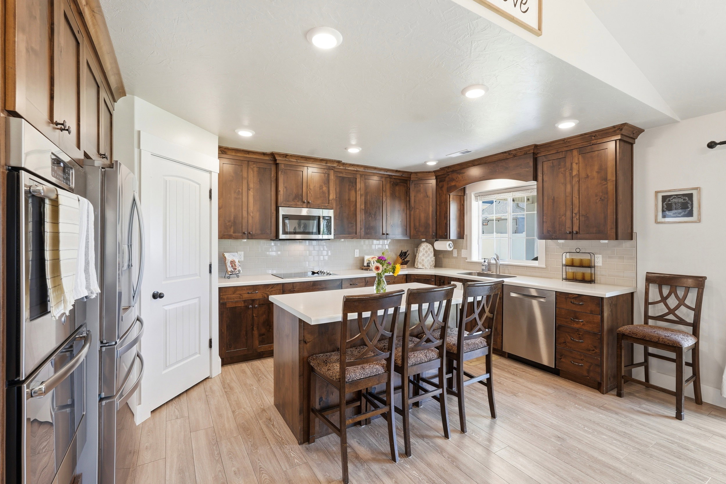 Modern kitchen featuring wood-finish flooring, recessed lighting, and a white paneled door