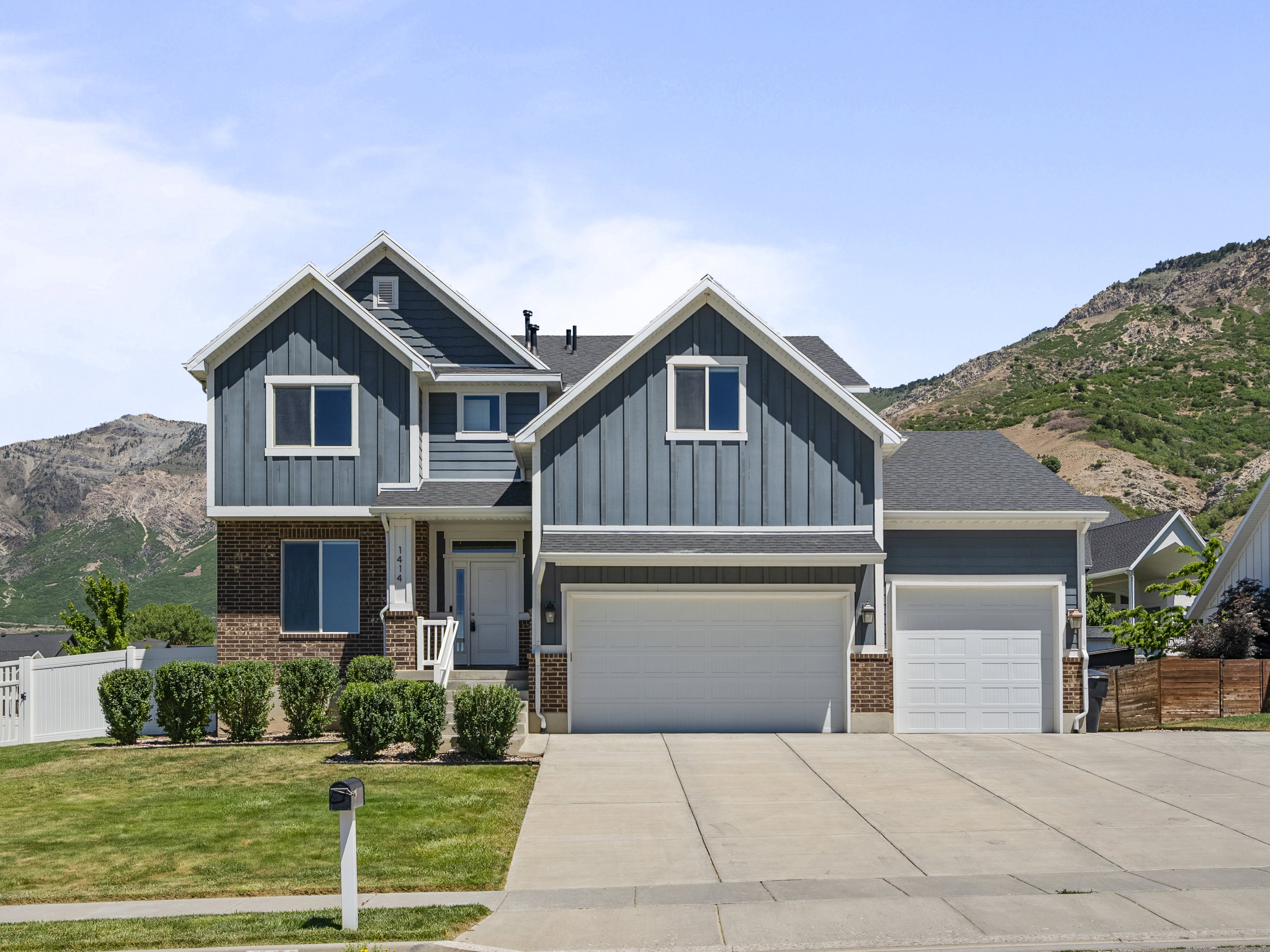 Two-story exterior featuring blue vertical siding and brick accents