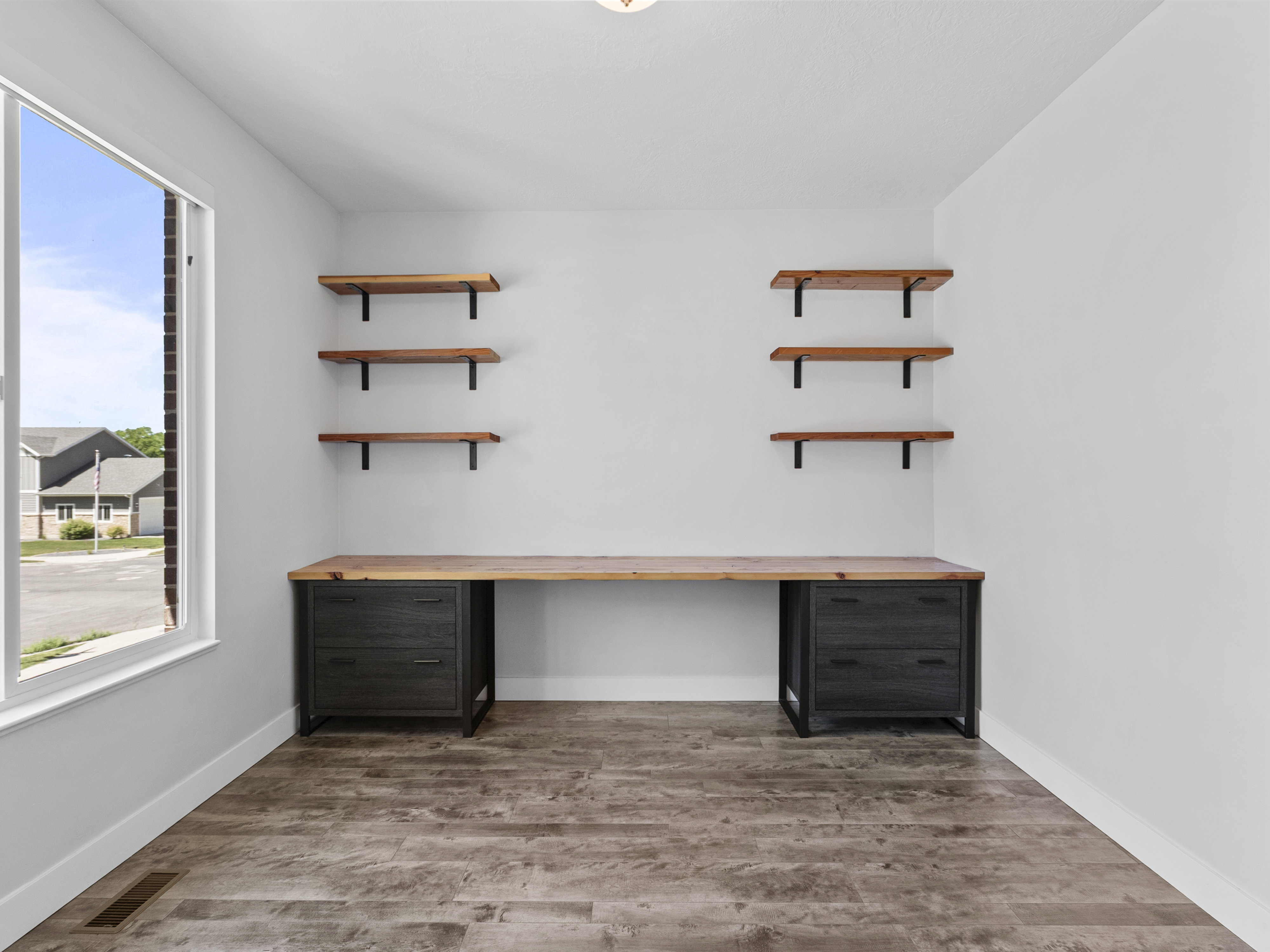 Dedicated space featuring a built-in wood-finish desk with dark cabinetry