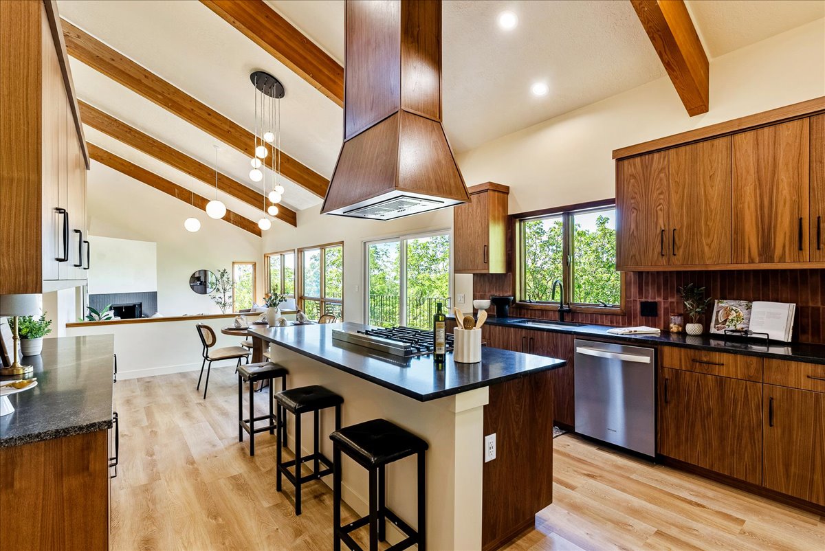 Kitchen featuring wood-finish cabinetry, black countertops, and stainless steel appliances