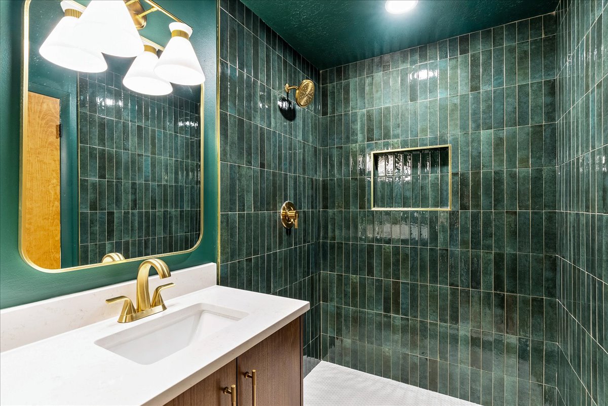 Contemporary bathroom featuring a vanity with a white countertop and gold-toned fixtures