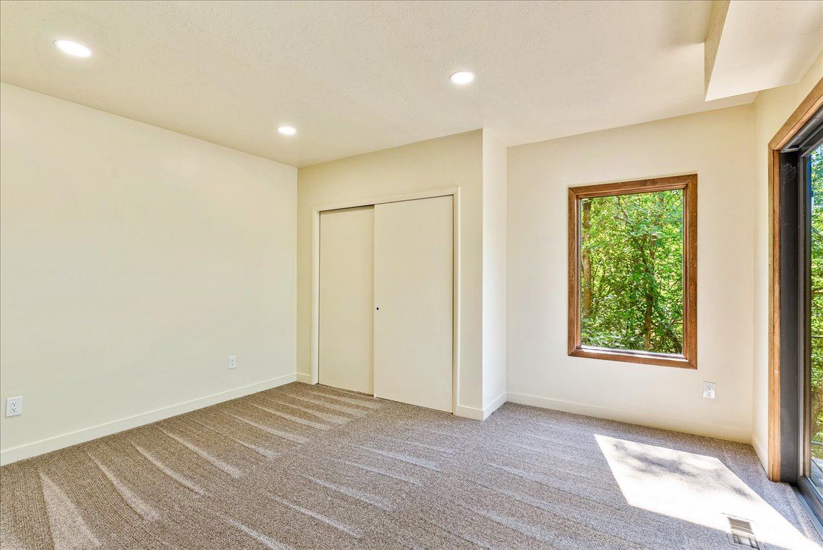 Neutral tone walls with recessed lighting and textured carpet flooring