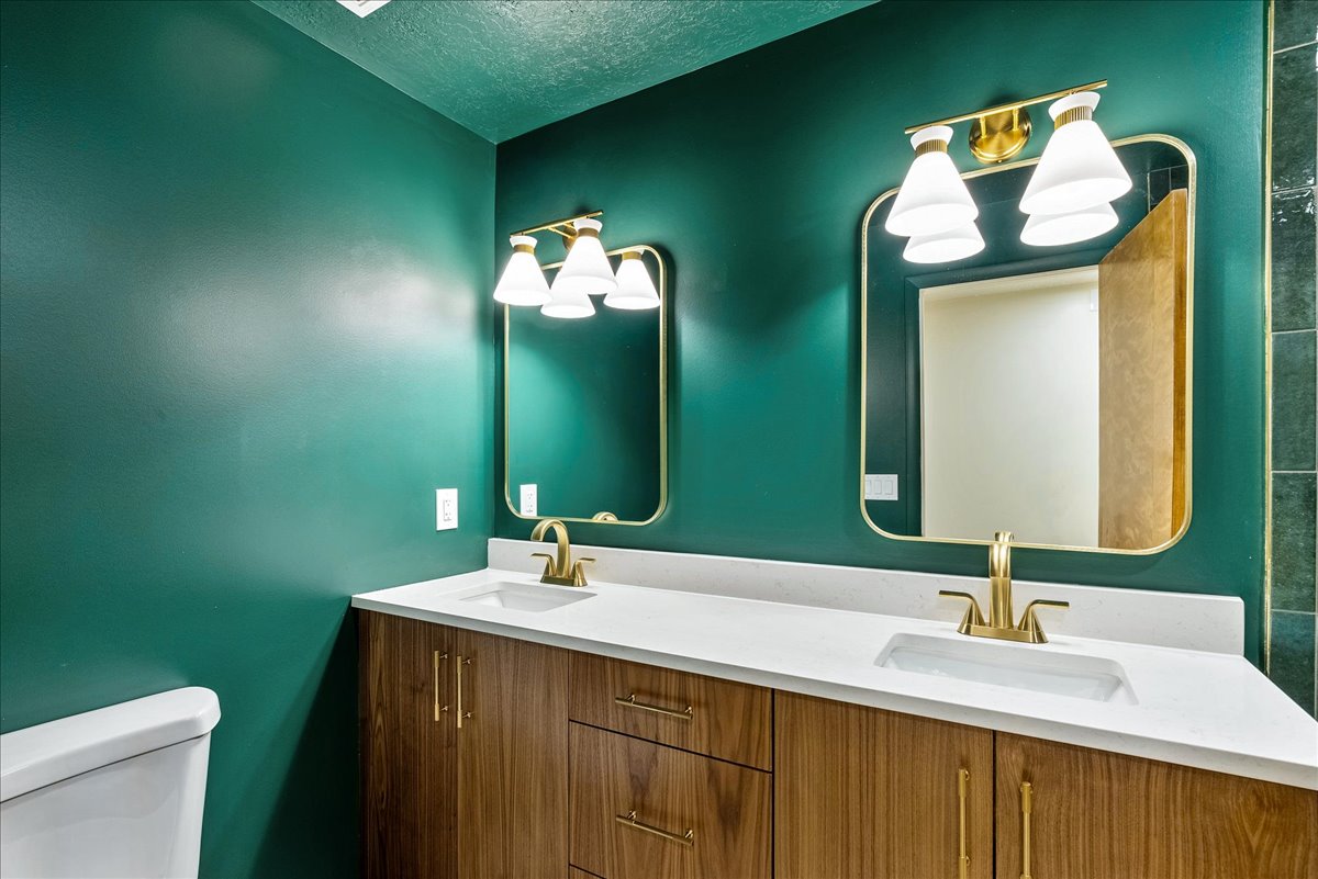 Dual vanity with wood-finish cabinetry and brass hardware