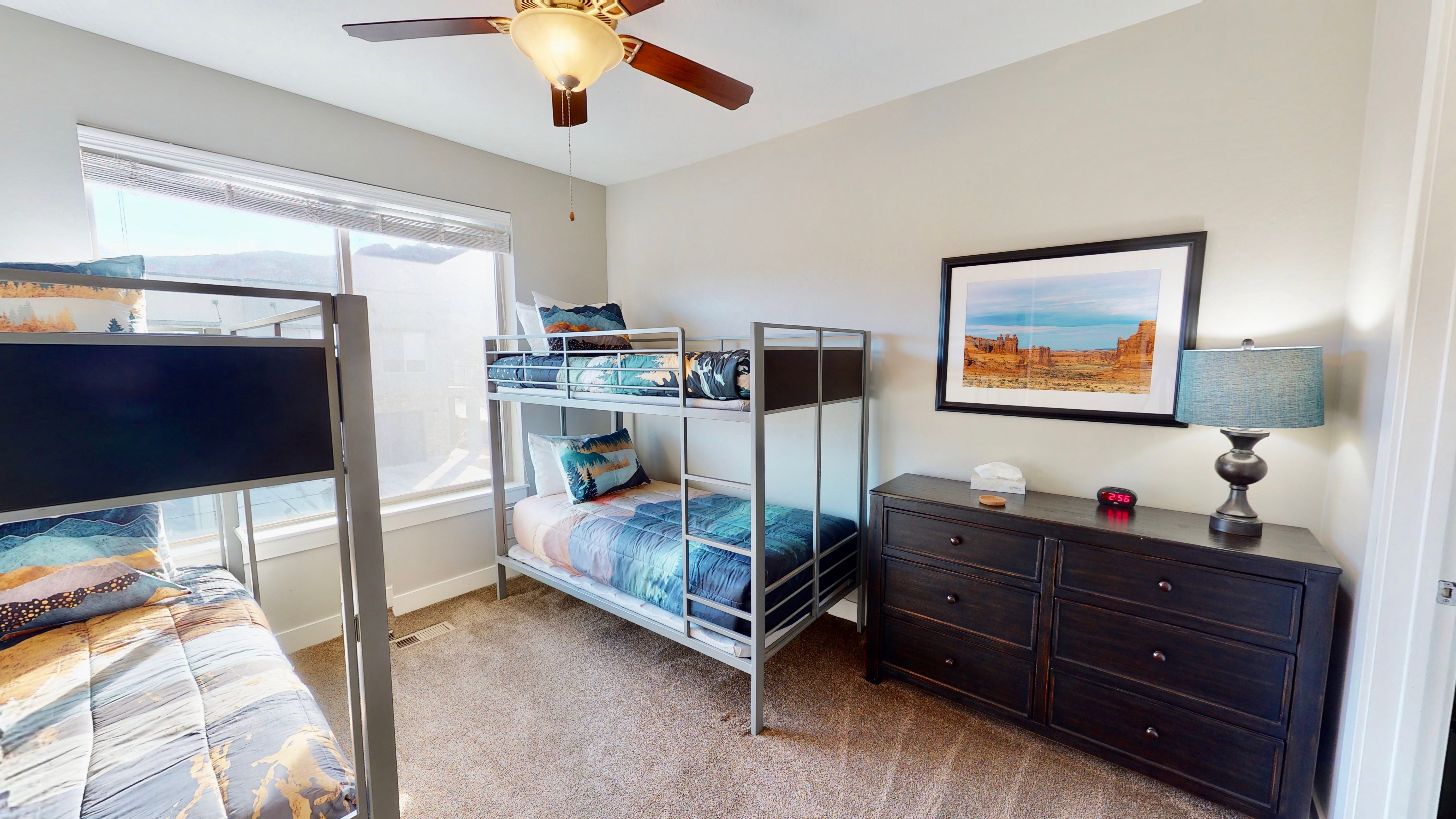 Carpeted room featuring a ceiling fan with integrated lighting, a large window, and light gray wall paint