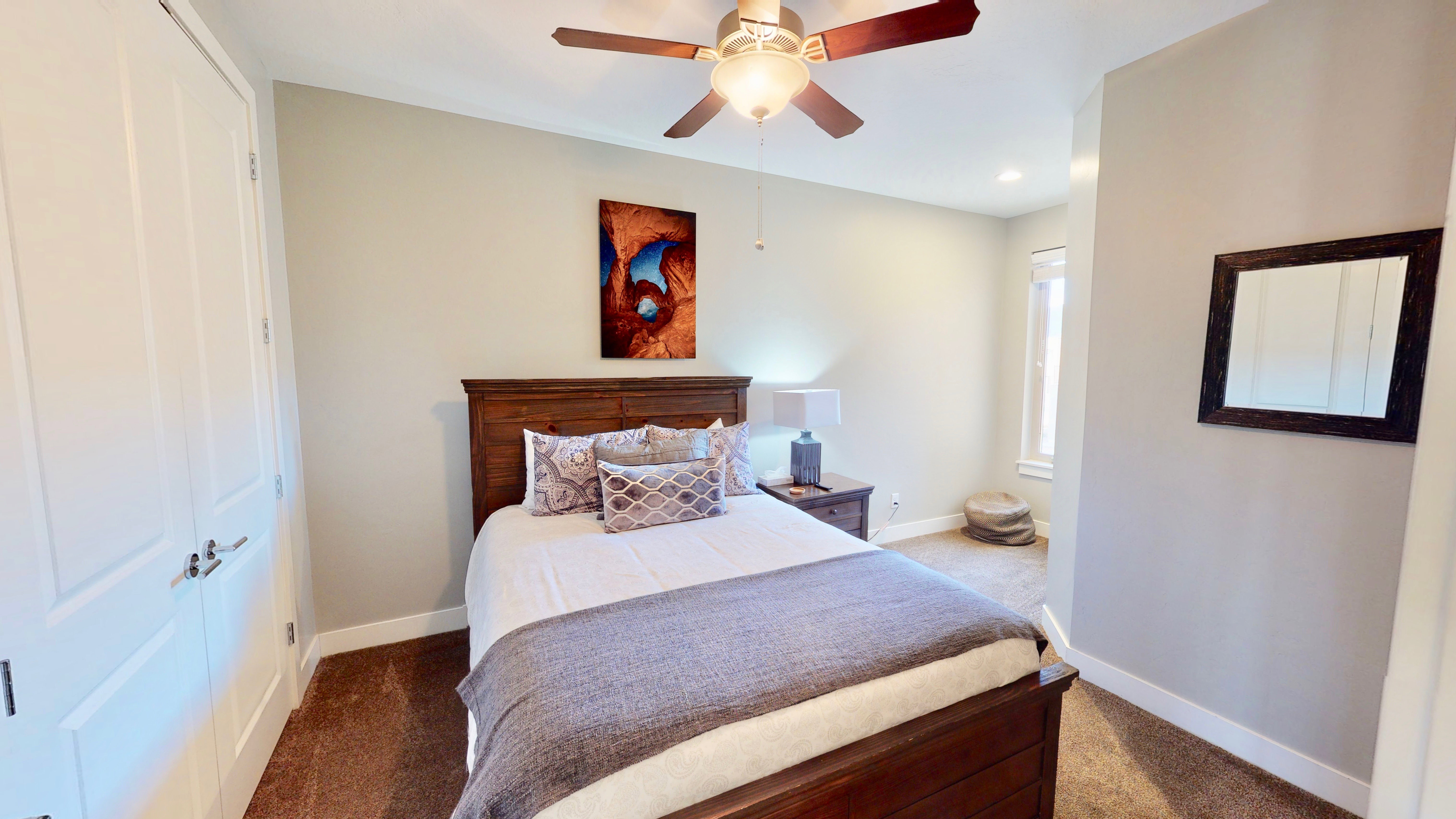 Bedroom featuring a ceiling fan with integrated lighting, a light-toned wall color, and plush carpeting