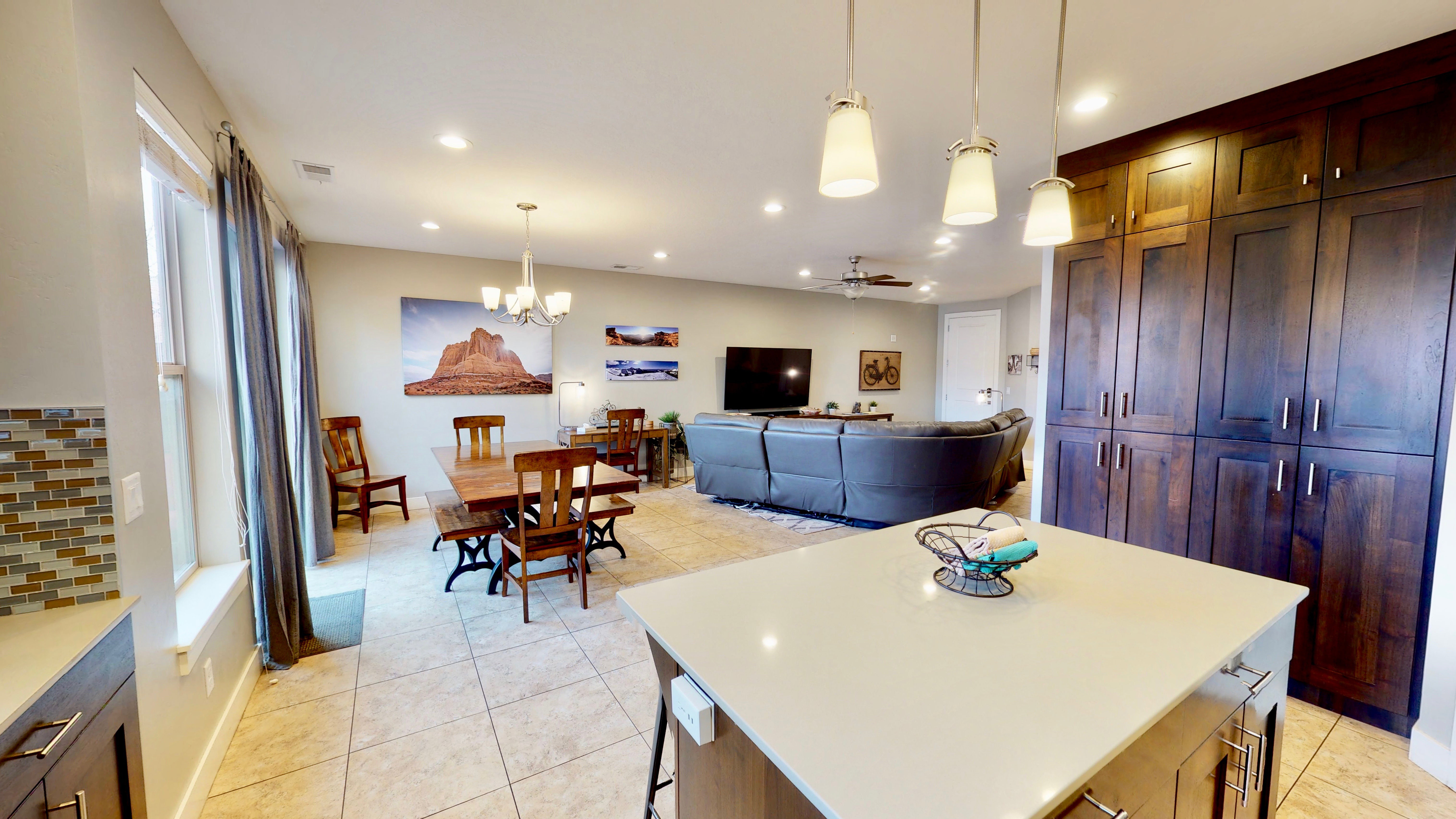 Open-concept living space featuring a central kitchen island, tile flooring, and dark wood-finish cabinetry
