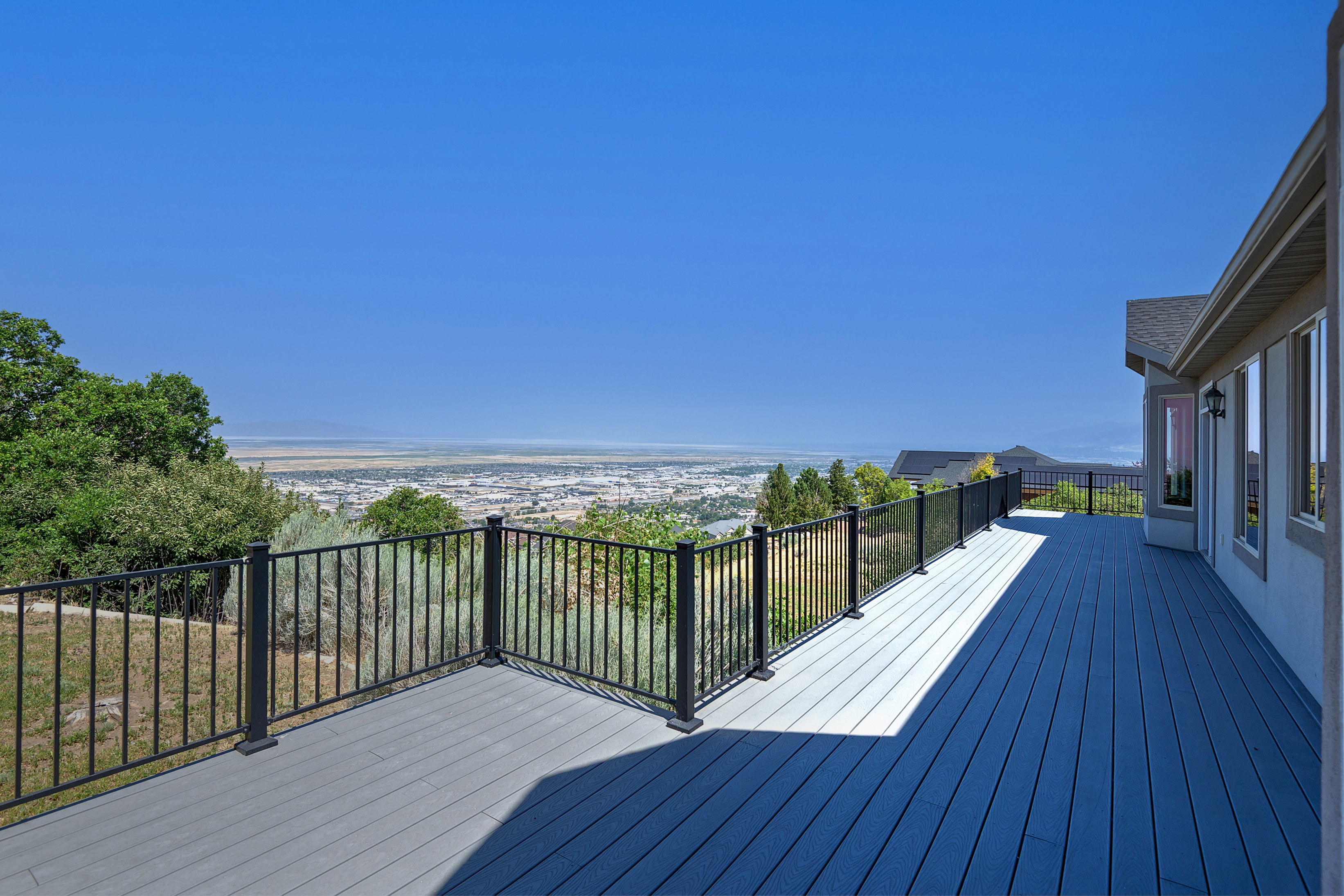 Expansive outdoor deck with composite decking and black metal railings