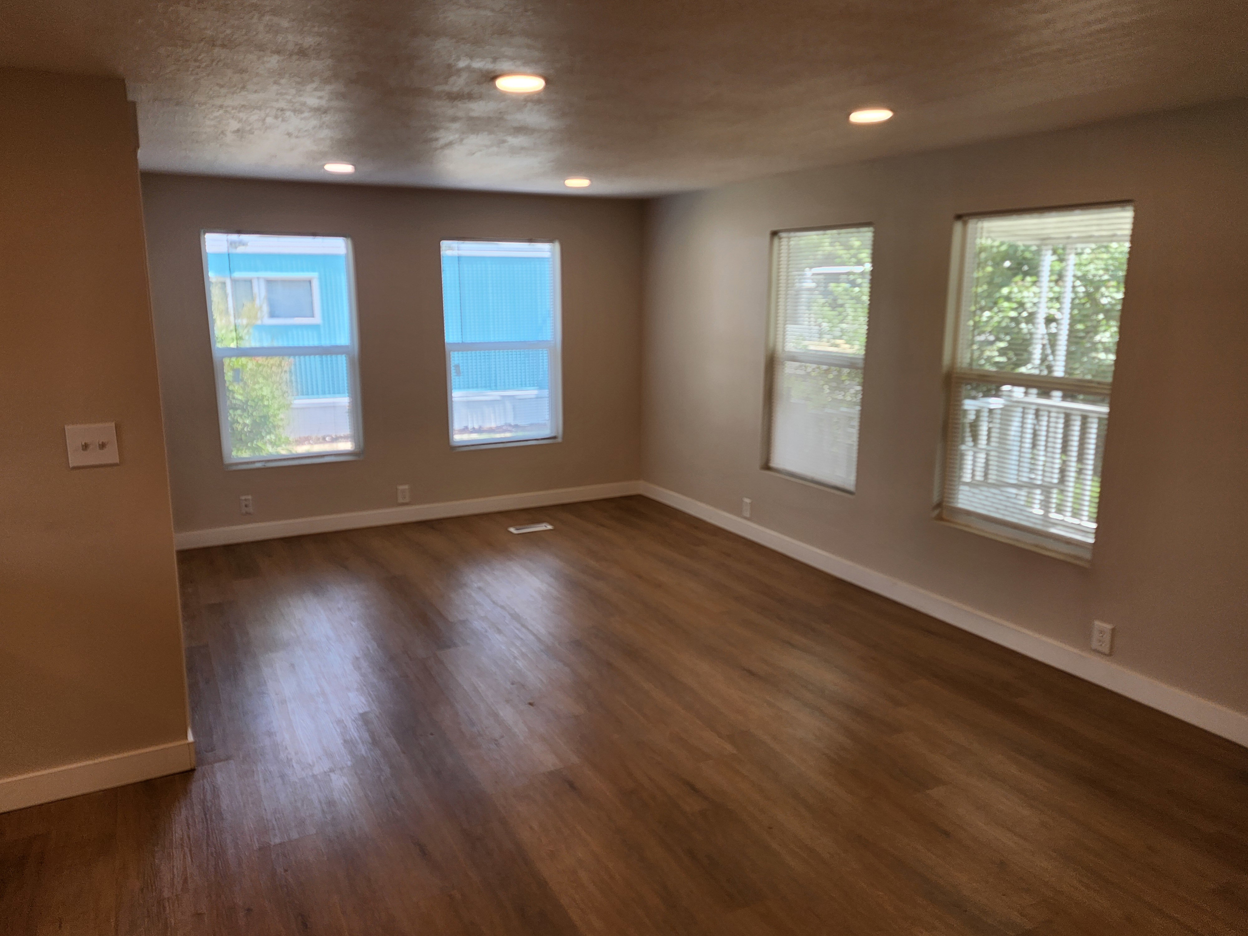 Spacious interior featuring wood-finish flooring, recessed lighting, neutral paint, and multiple windows