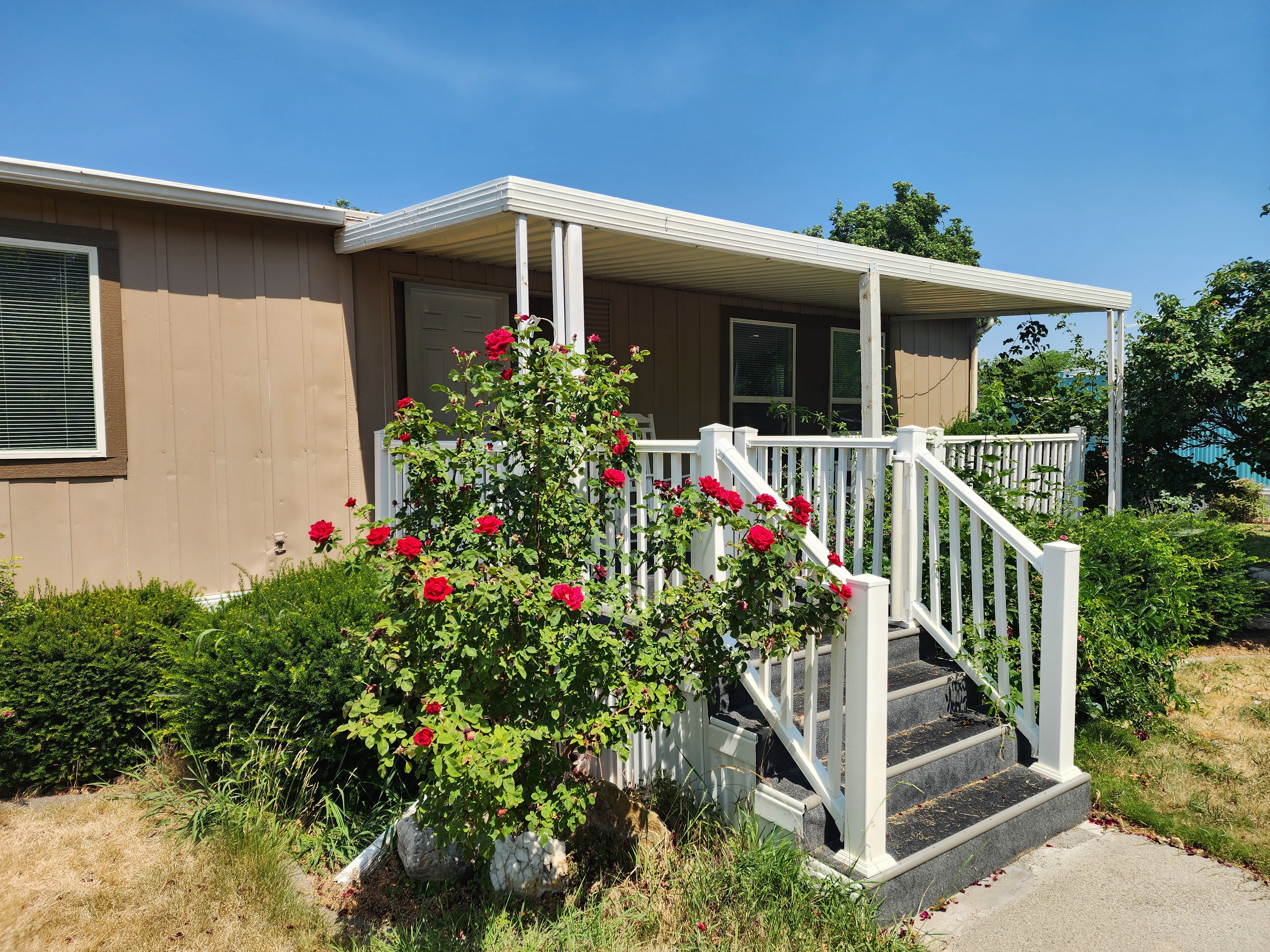 Covered porch with white railings and steps