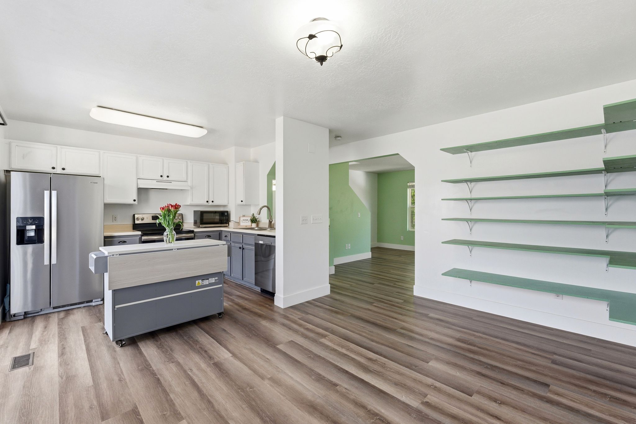 Open-concept kitchen and living area featuring wood-finish flooring