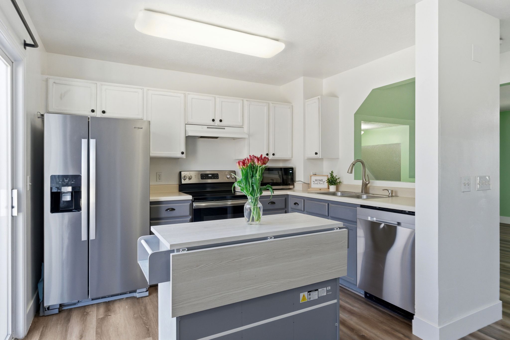 Well-appointed kitchen featuring a stainless steel refrigerator, dishwasher, and range