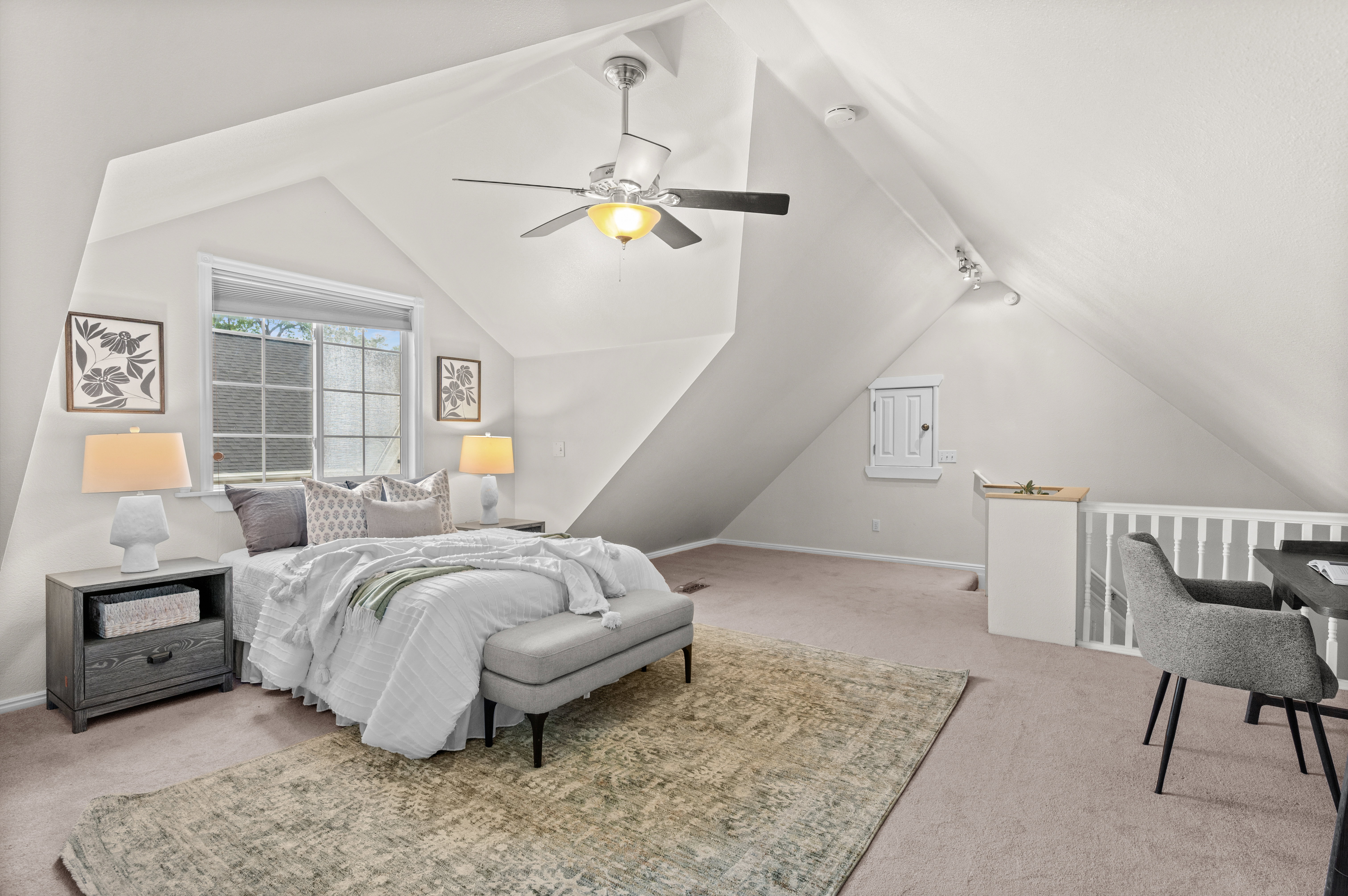 Carpeted room with a window, ceiling fan, and sloped ceilings