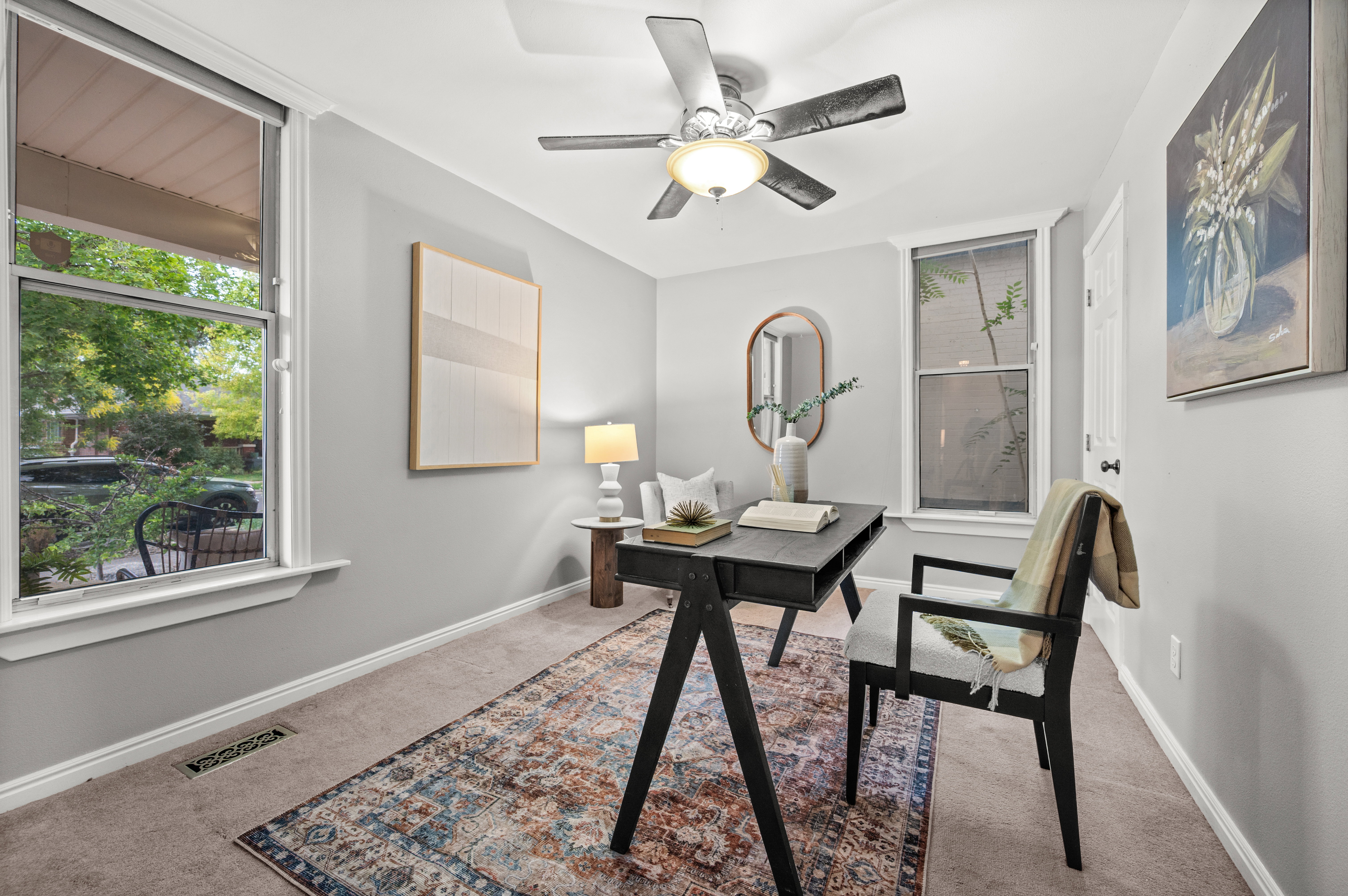 Carpeted room featuring light gray walls, white trim, and a ceiling fan with integrated lighting