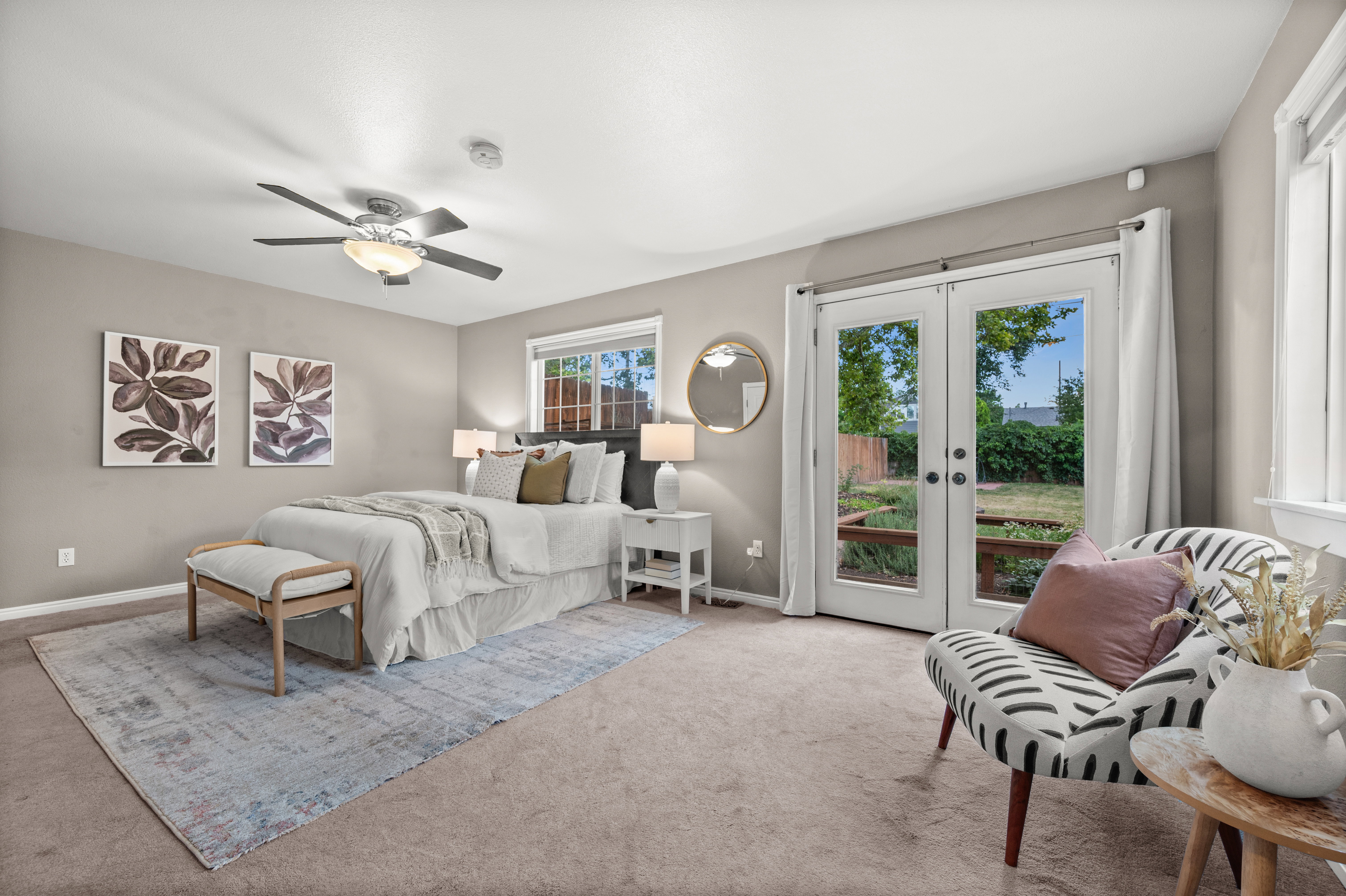 Carpeted bedroom with a ceiling fan light fixture and neutral wall color