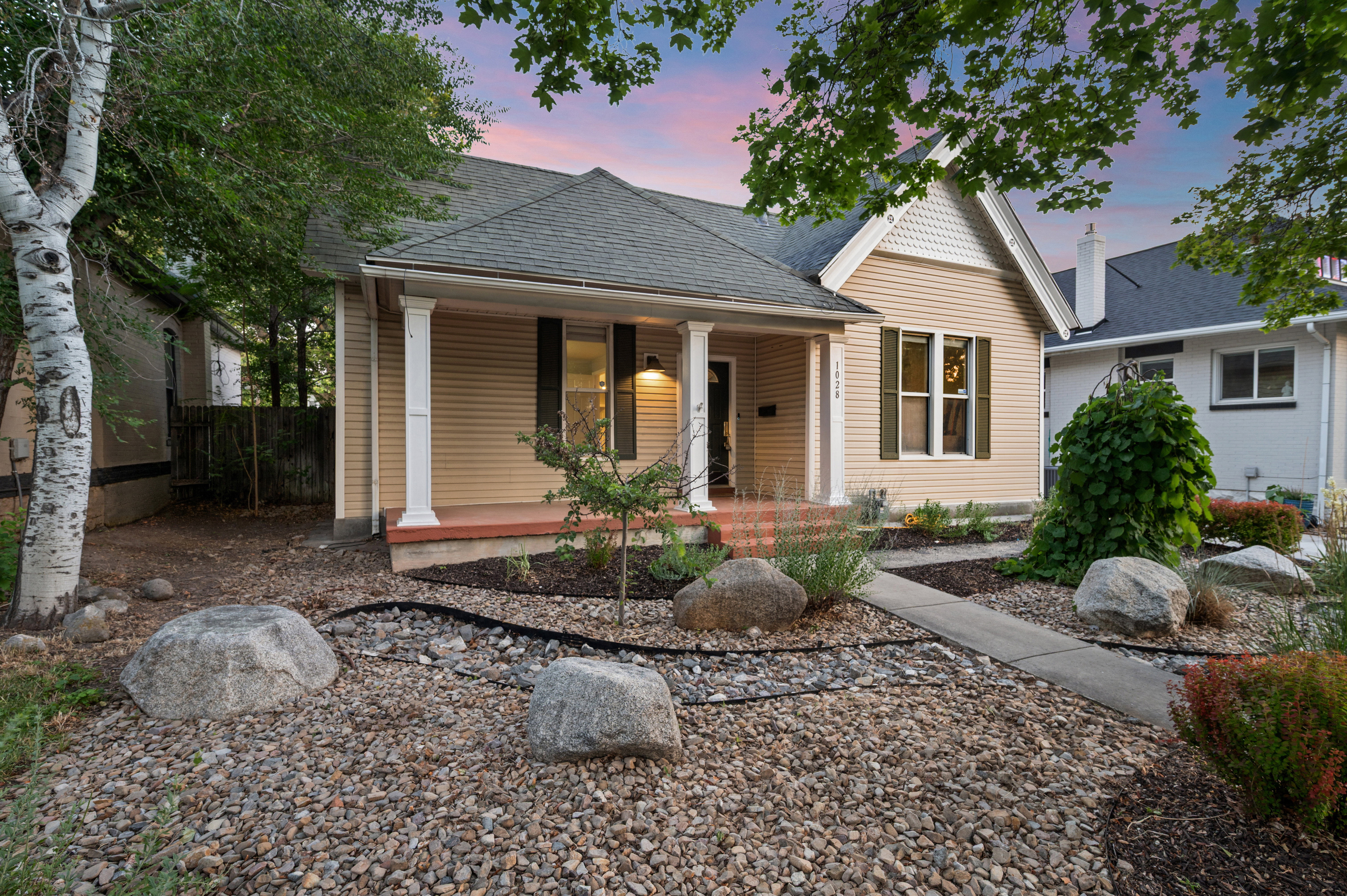 Traditional-style home featuring horizontal siding, a covered front porch with white columns, and a gabled roof