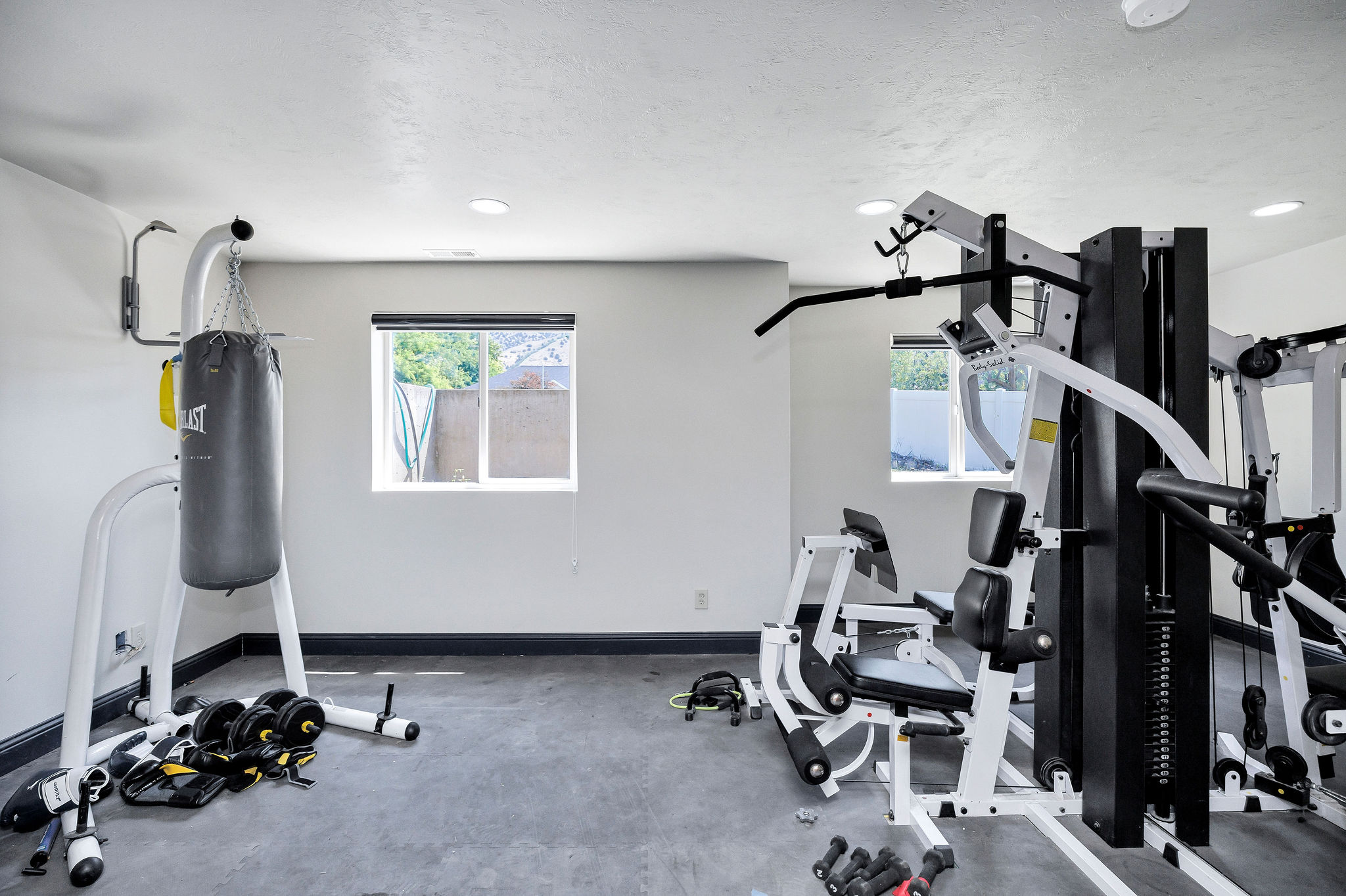 Dedicated fitness space featuring recessed lighting, two windows, and dark-finish baseboards