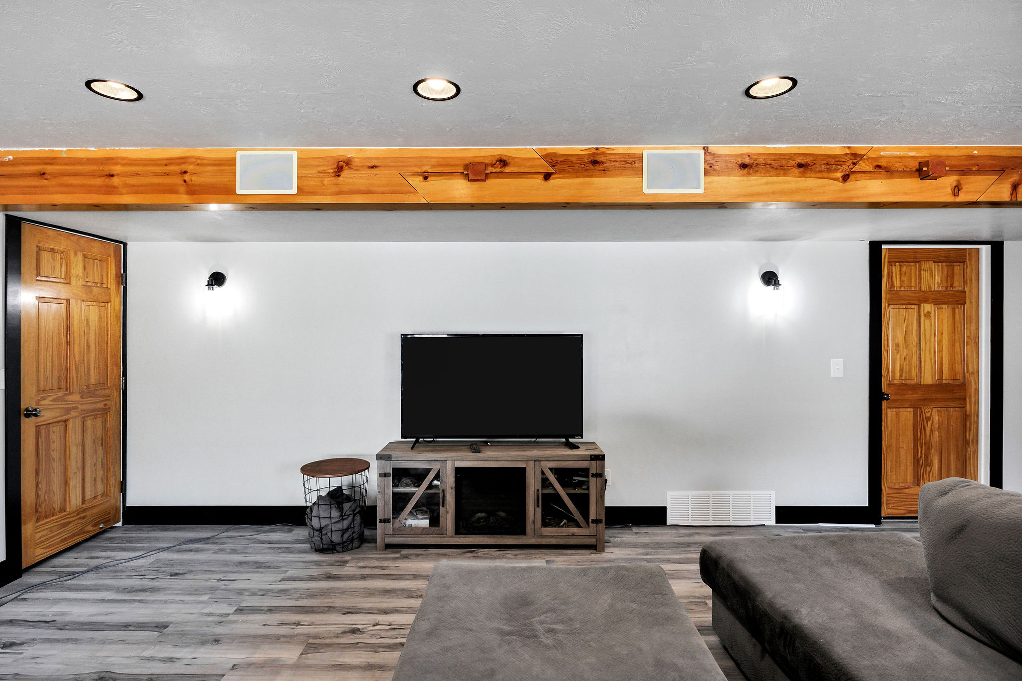 Living area featuring a prominent wood beam with recessed lighting and integrated speakers
