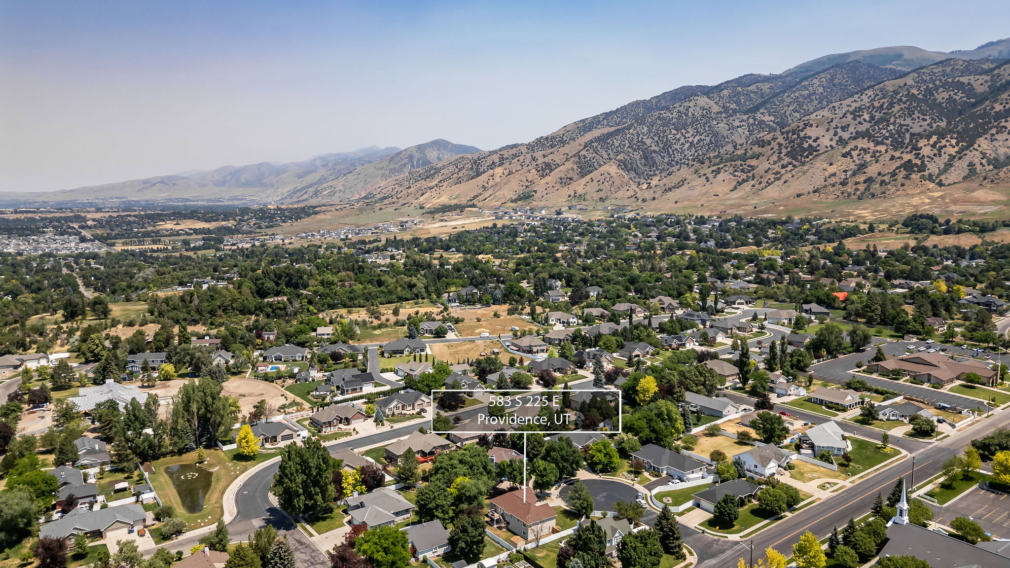 Aerial perspective showcasing a residential neighborhood against a mountain backdrop