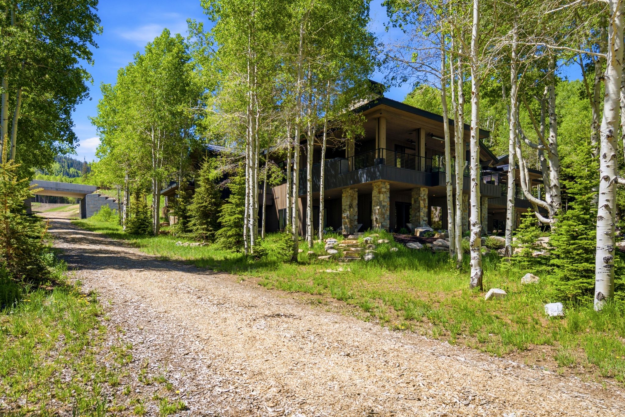 Expansive gravel driveway leading to a multi-story residence