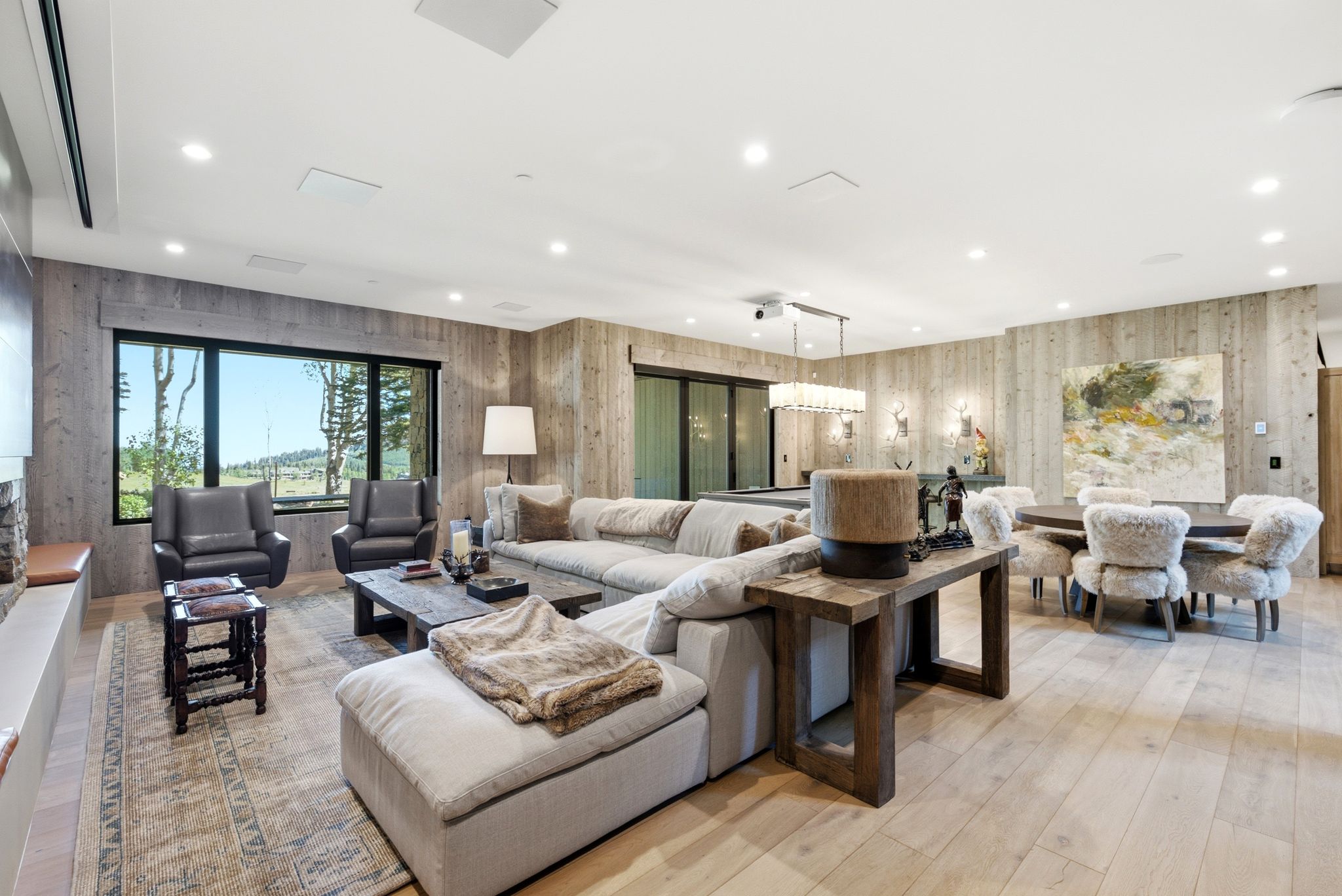 Spacious living area featuring wood-finish flooring, recessed lighting, and large windows