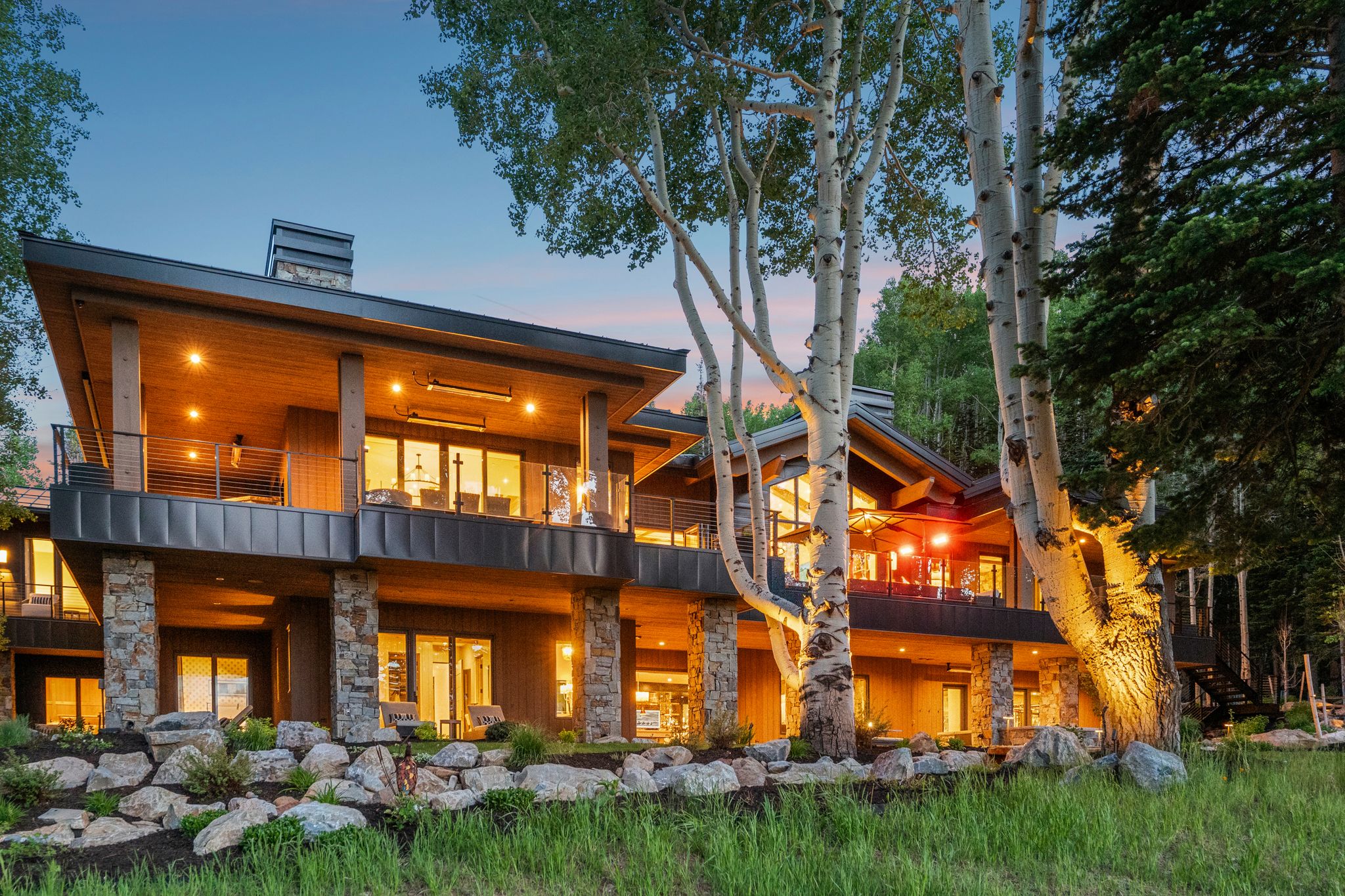Multi-level exterior featuring natural wood siding and stone pillar accents