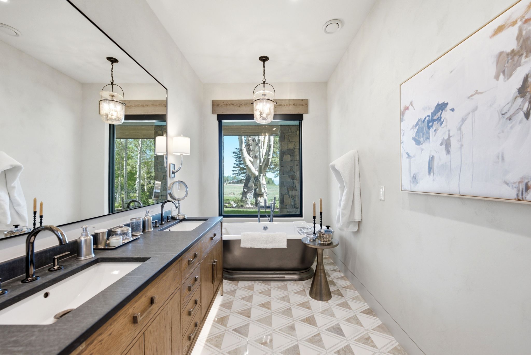 Spacious bathroom featuring a dual vanity with undermount sinks, a dark countertop, and wood cabinetry