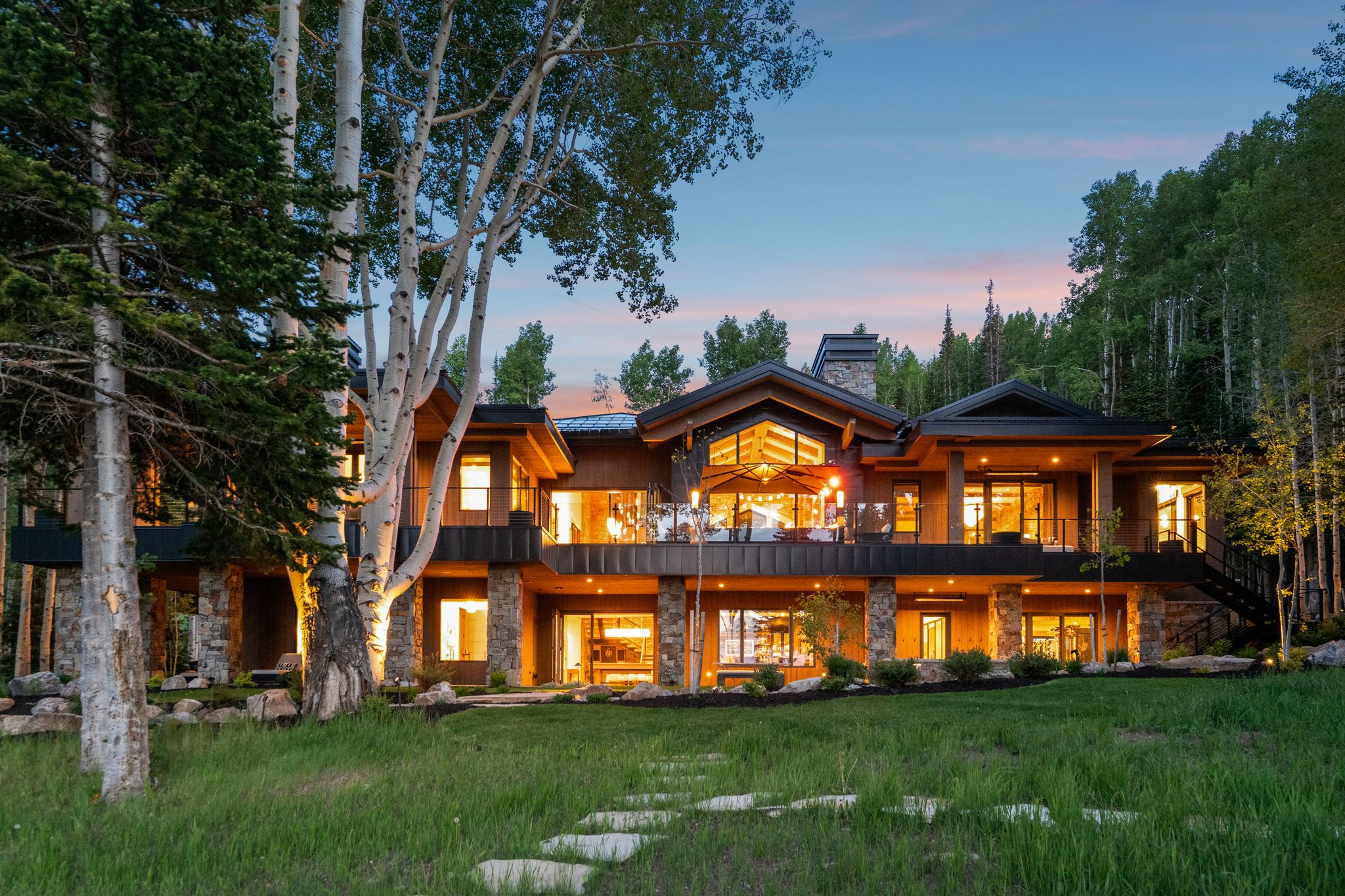 Expansive multi-level residence featuring wood siding and stone accents