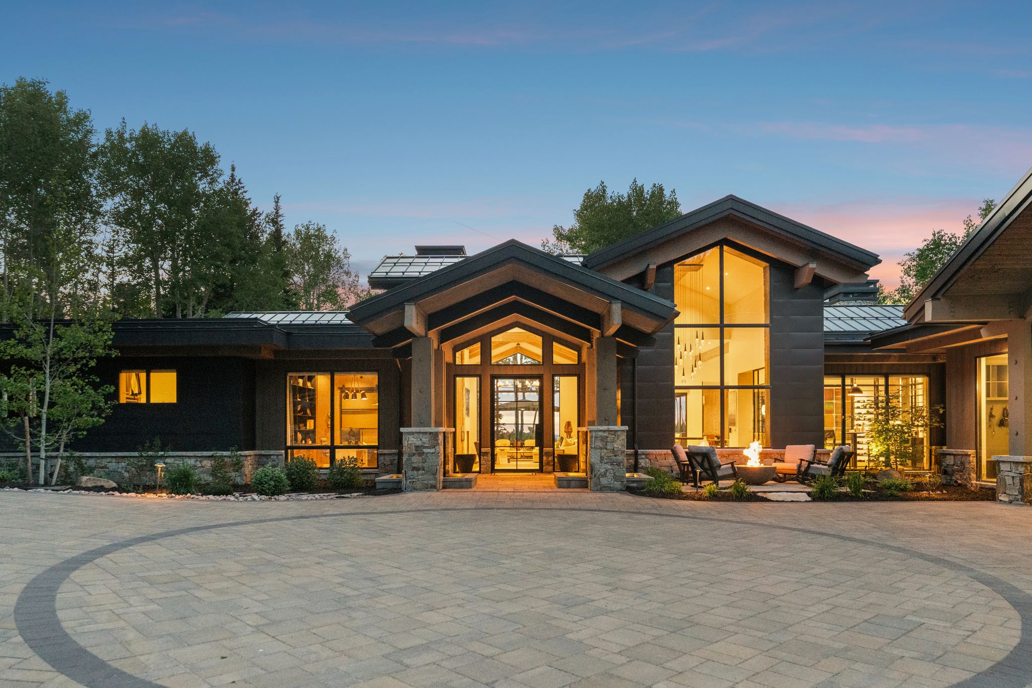 Contemporary exterior featuring extensive glass, stone accents, and dark siding