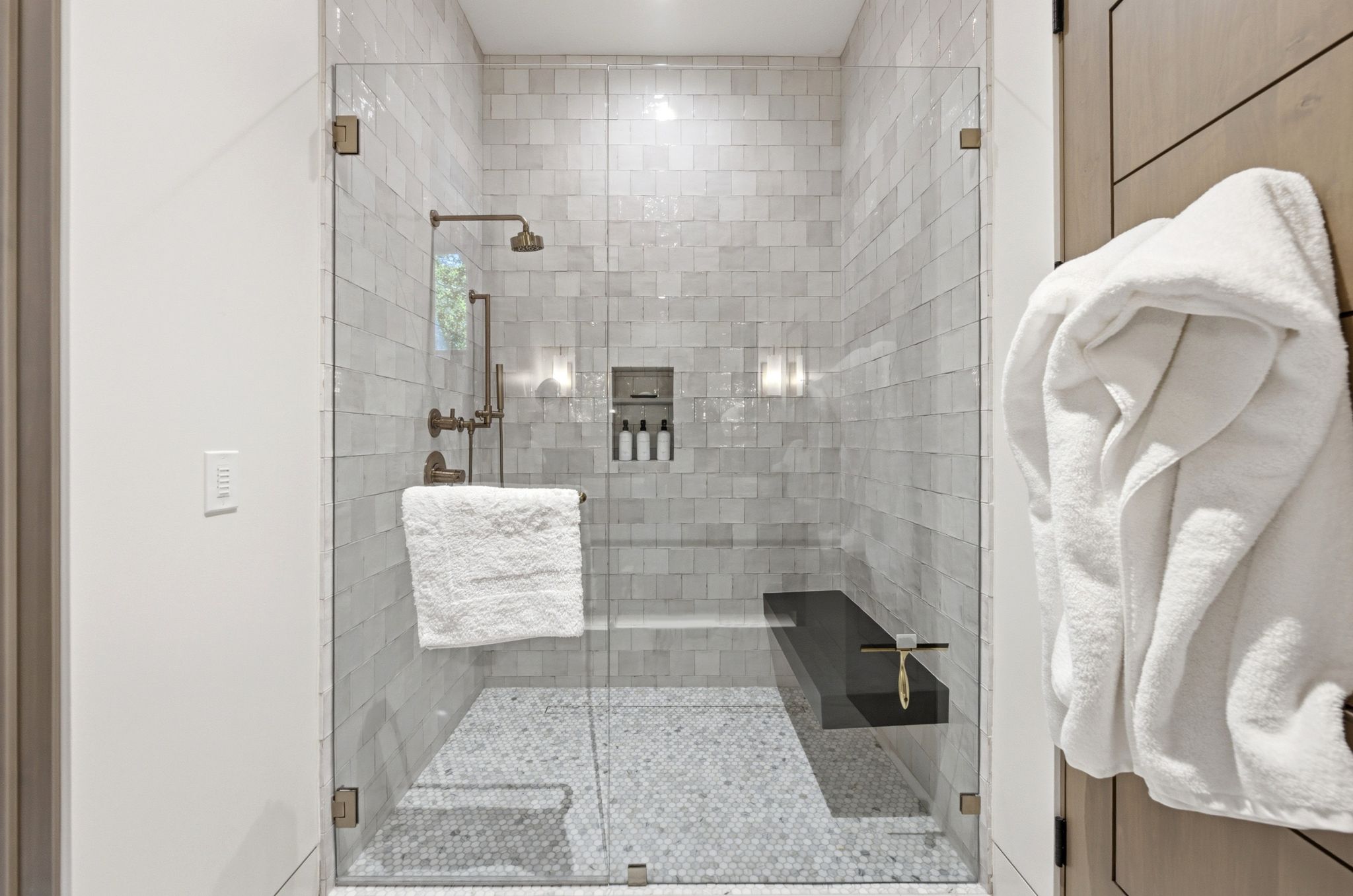 Walk-in shower with clear glass enclosure and bronze hardware