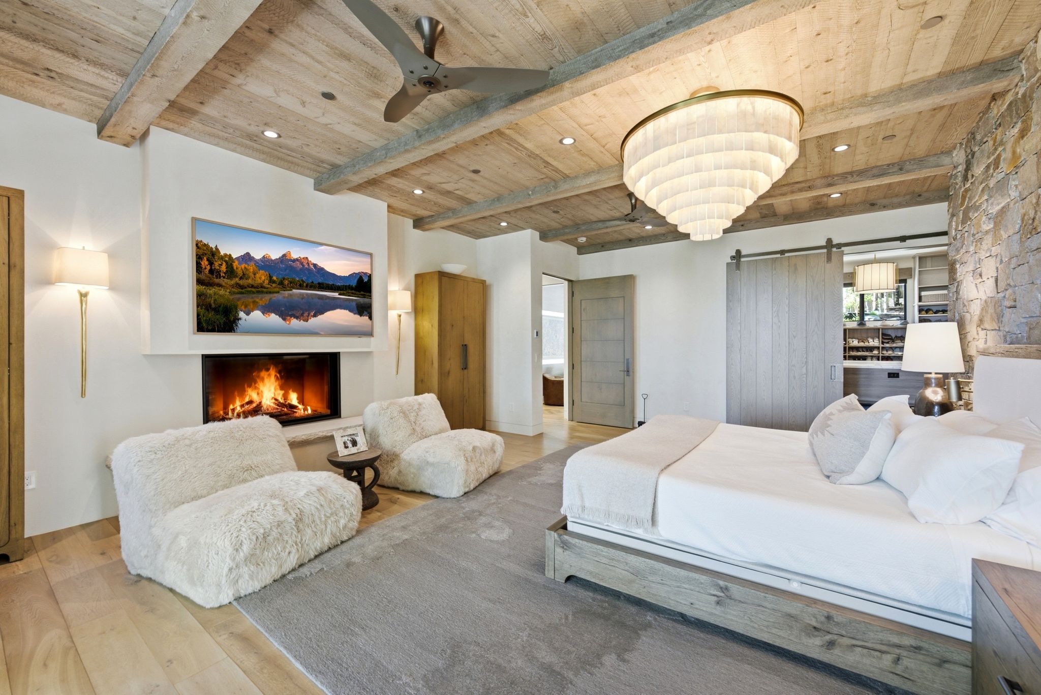 Wood-finish beamed ceiling with recessed lighting and a contemporary chandelier