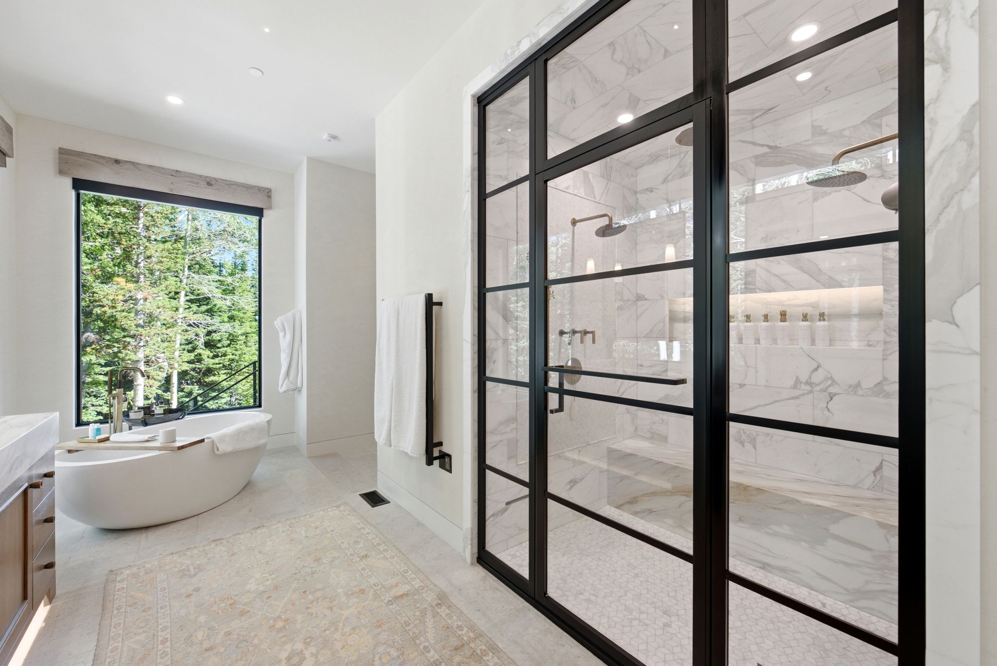 Freestanding soaking tub positioned before a large picture window