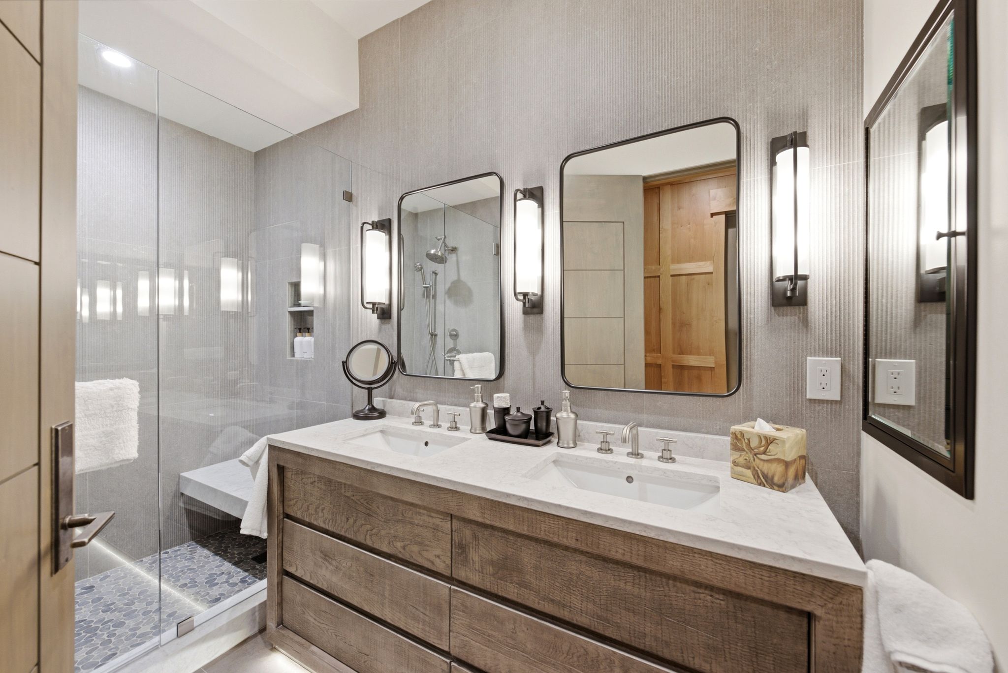 Double vanity with dual undermount sinks, stone countertops, and dark wood-finish cabinetry
