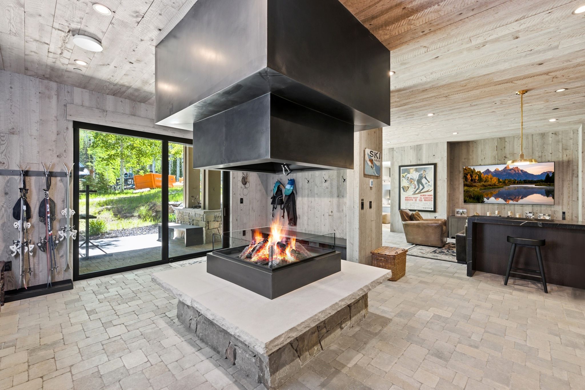 Central fireplace with a metal hood and glass surround