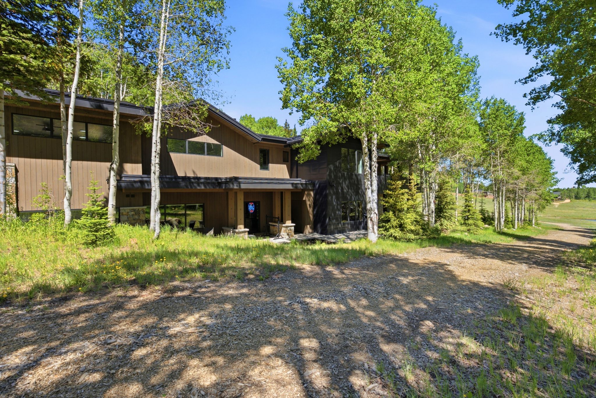 Contemporary exterior with brown siding, dark trim, and stone accents