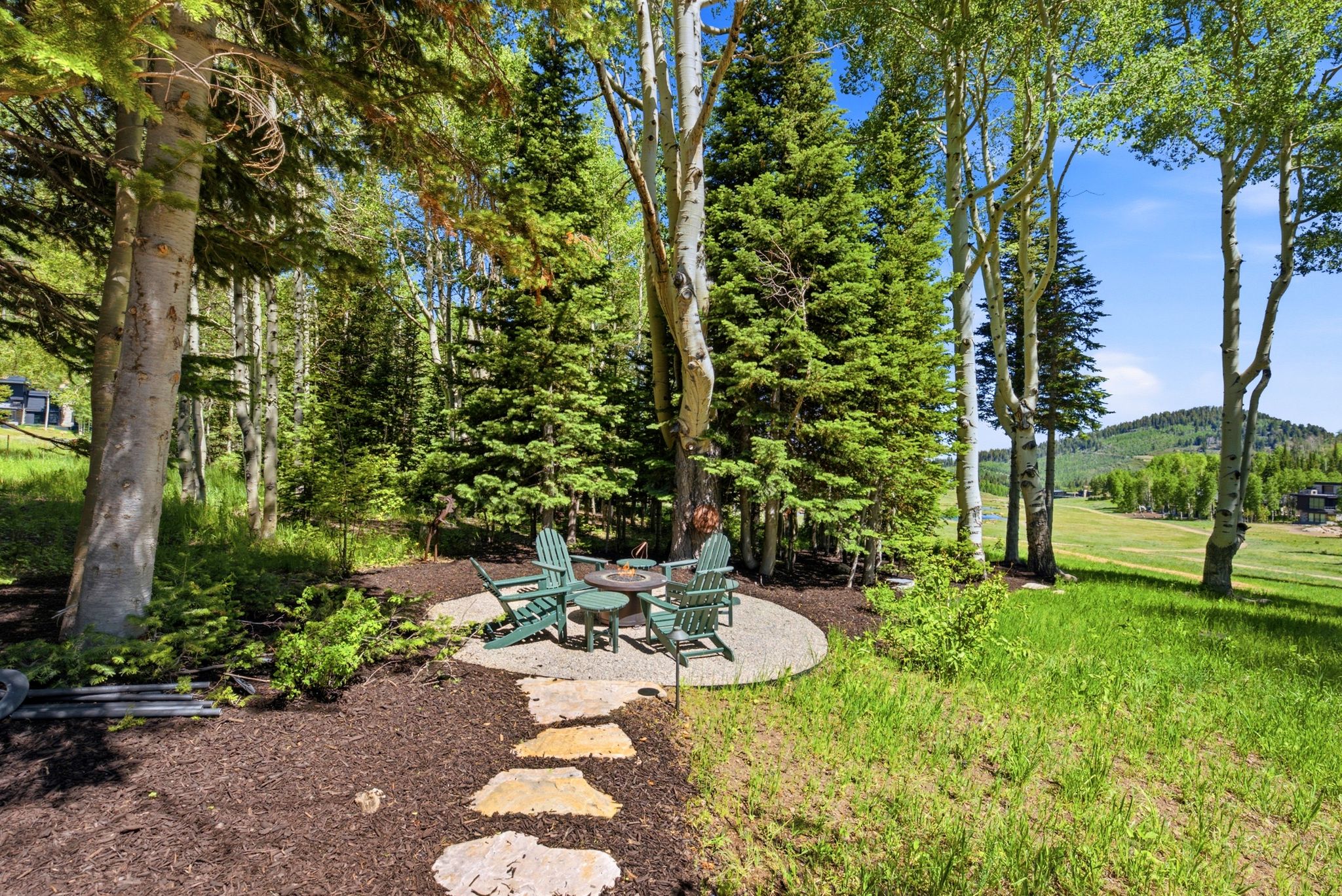 Stone patio area surrounded by mature trees